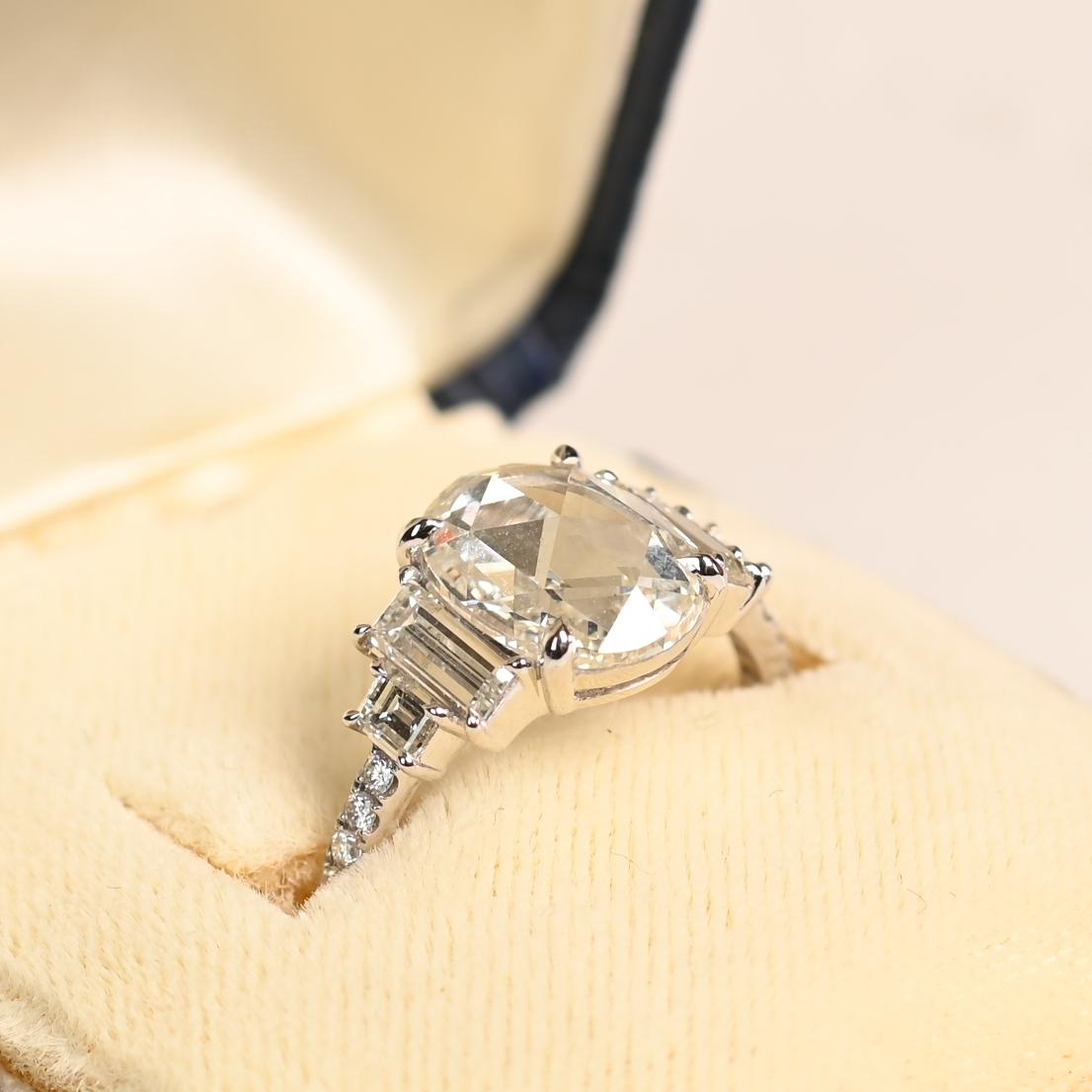 Este exquisito anillo exhibe un impresionante diamante ovalado talla rosa de aproximadamente 2 quilates, certificado por el GIA por su excepcional calidad. De color I y claridad VVS2, el diamante central posee un brillo y una transparencia