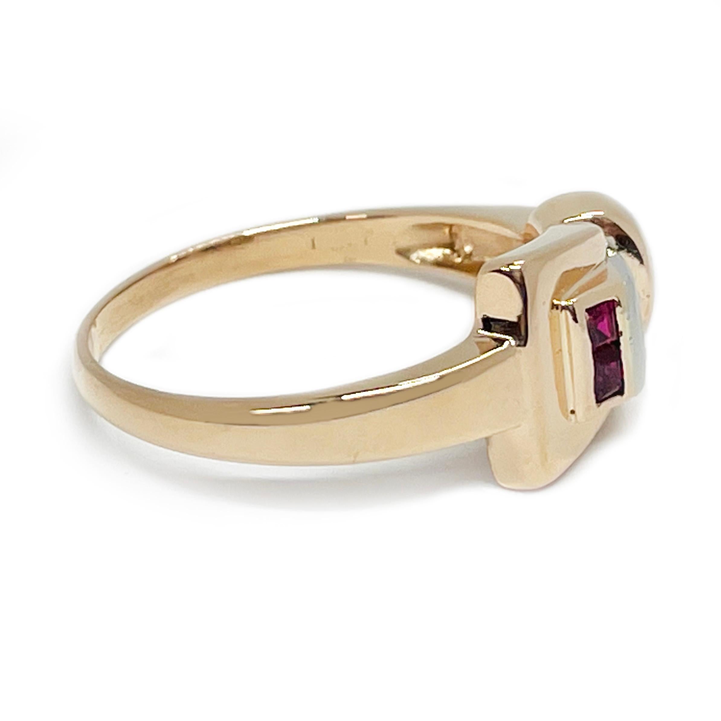 Platinum 14 Karat Rose Gold Diamond Ruby Buckle Ring. The ring features a belt buckle design with a bead set center diamond and two accent square-cut rubies bezel-set along the inside of the buckle. The round center diamond has a total carat weight