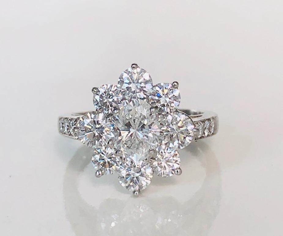 Platinum Rosette style Diamond Ring, set with a fine quality oval center  diamond and 14 round diamond for a total of 2.19 carats.

We design and manufacture all our jewelry in our workshop, located in New York City's diamond district.