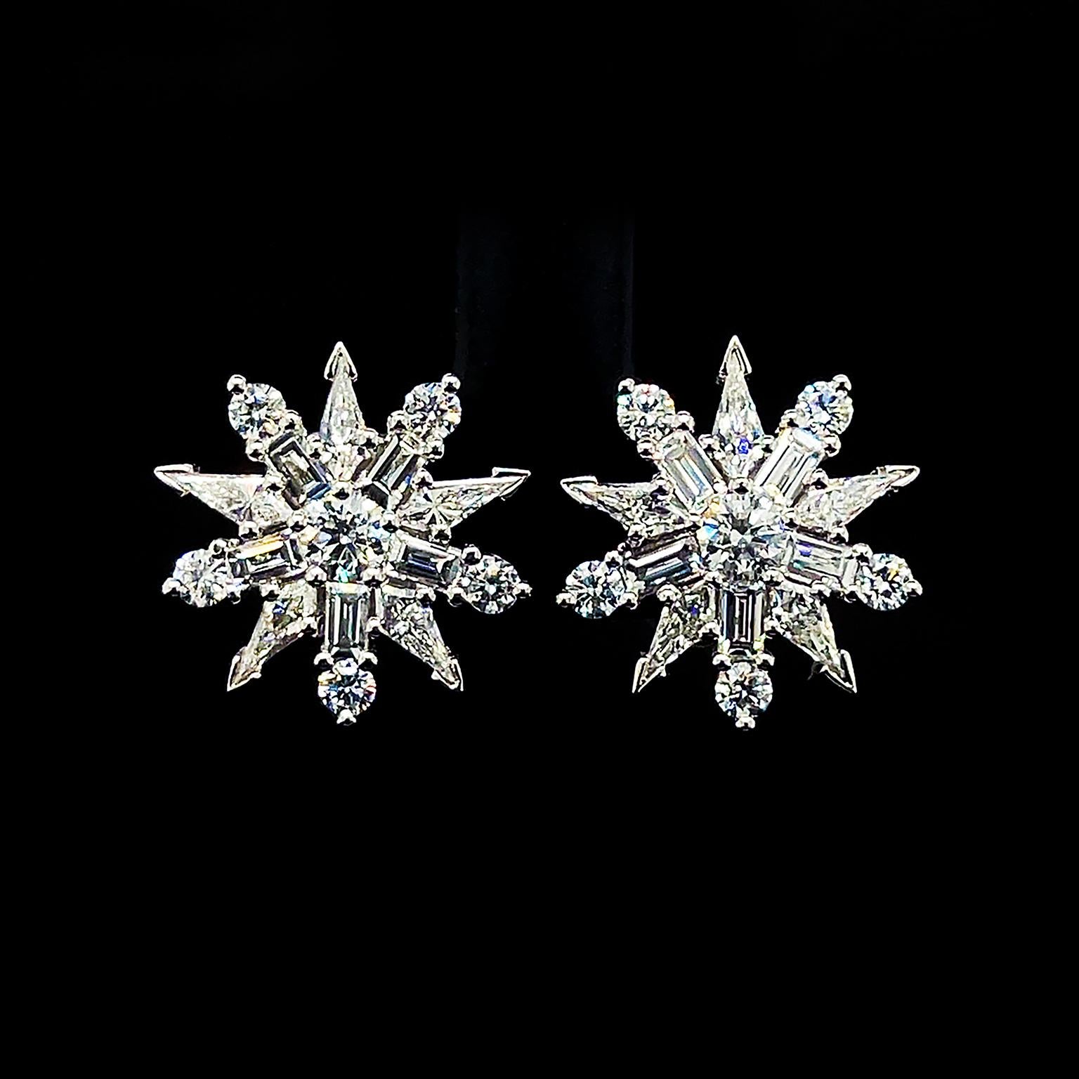 A fiery illustration of a star glows in gleaming diamonds. Various cuts of the precious gemstone are joined together for this distinct design. A round cut is in the center, while five baguette shapes extend outward. Each baguette diamond features a