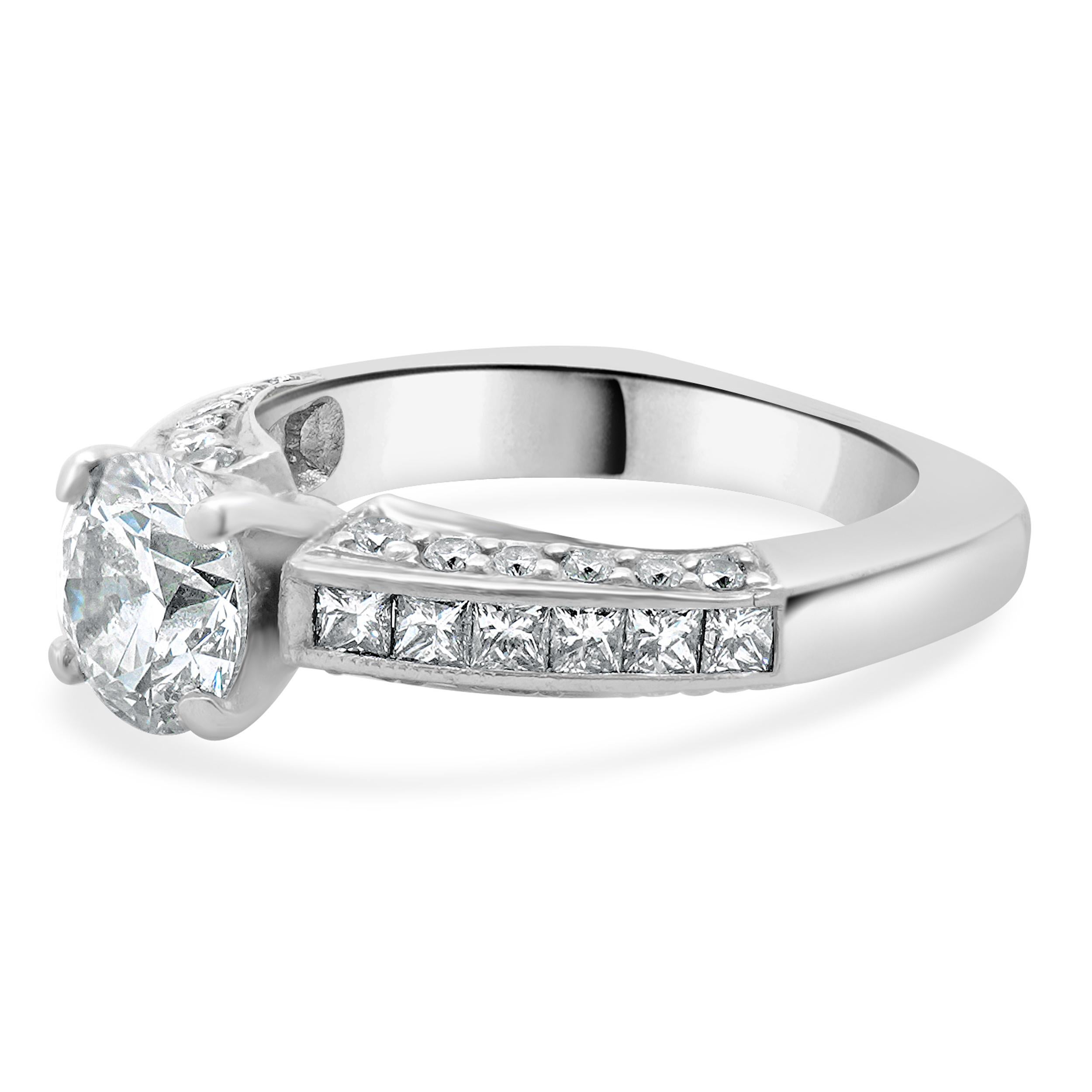 Designer: custom design
Material: platinum
Center Diamond: 1 round brilliant cut = 1.27ct
Color : G
Clarity : SI1
Diamond: 36 round and princess cut = 0.72cttw
Color : G / H
Clarity : SI1-2
Dimensions: ring top measures 4.7mm
Size: 5.5 complimentary