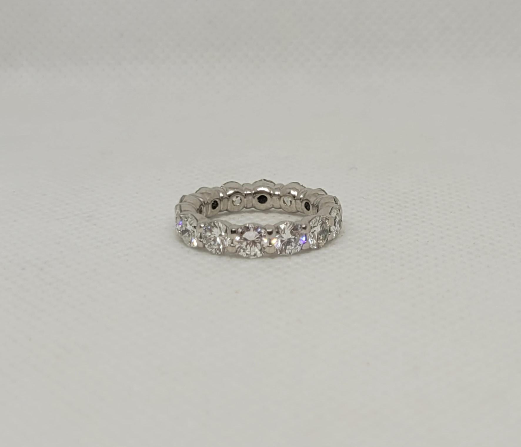 The platinum round brilliant diamond eternity ring is stunning, featuring fourteen diamonds totaling approximately 3.50 carats. Each diamond is prong-set, 4.1mm in diameter, and exhibits a G/H color and VS clarity, with exceptional brilliance and