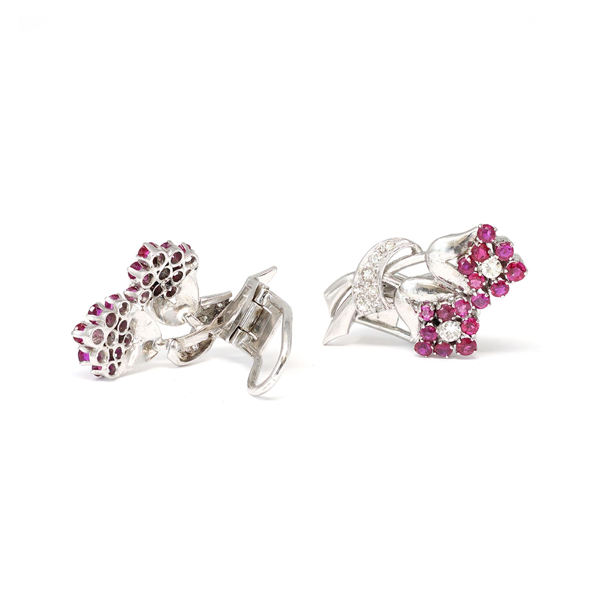An elegant clip on earrings circa 1950 featuring tiny flowers made of round rubies and diamonds. Styled in Platinum, the diamonds have an estimated weight of 0.70 carats, GH color and VS clarity. The vibrant red rubies have an approximate weight of