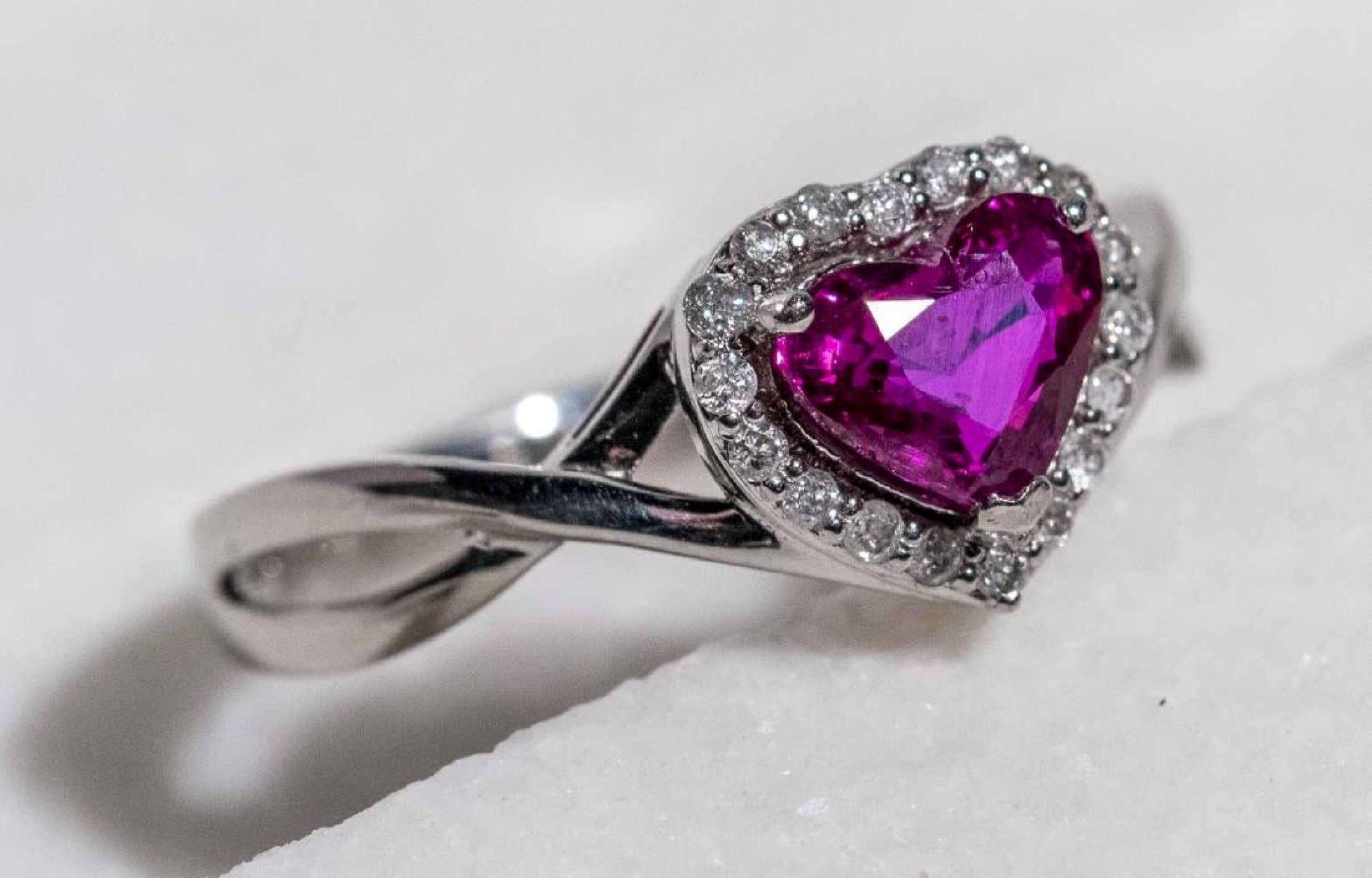 Platinum ring set with a heart shaped faceted ruby  (1.04 ct) within a border of round diamonds.( tcw .12), accompanied by GIA Ruby Report 2185383892 dated May 8 2017, stating NO HEAT TREATMENT).  Size 6 1/2  5.5 grams.