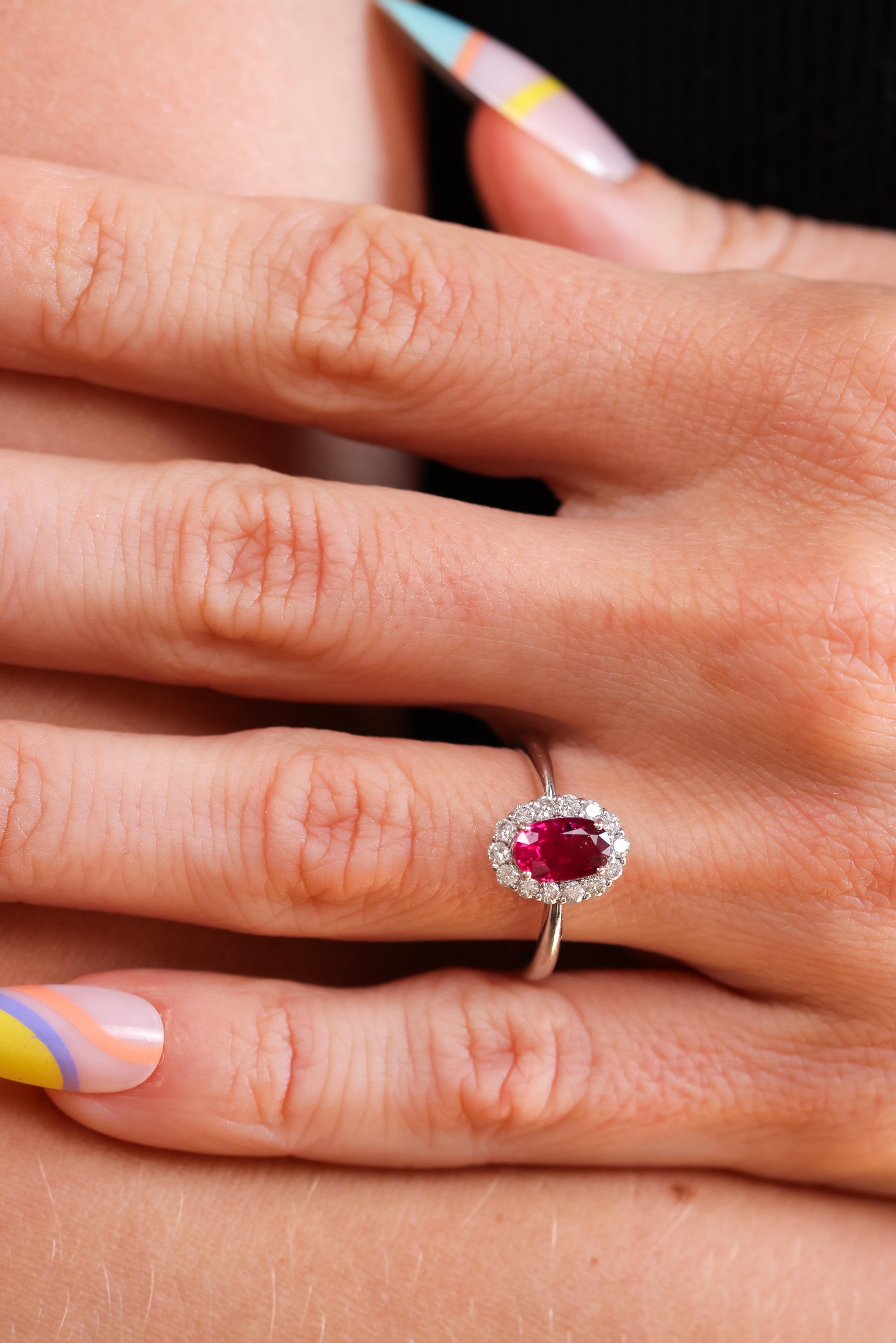This is an exquisite platinum, ruby and diamond engagement ring made in the early 2000's. The classic ring centers a bright, deep red Oval Mixed Cut ruby accompanied by a Guild Laboratories certificate stating the ruby weighs exactly 1.08cts and is