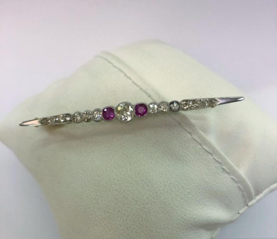 Italienische Vintage-Brosche aus Platin mit einem zentralen Brillanten von 0,4 Karat, flankiert von Rubinen und weiteren Diamanten / Made in Italy 1890-1930er Jahre
Länge 5.8cm