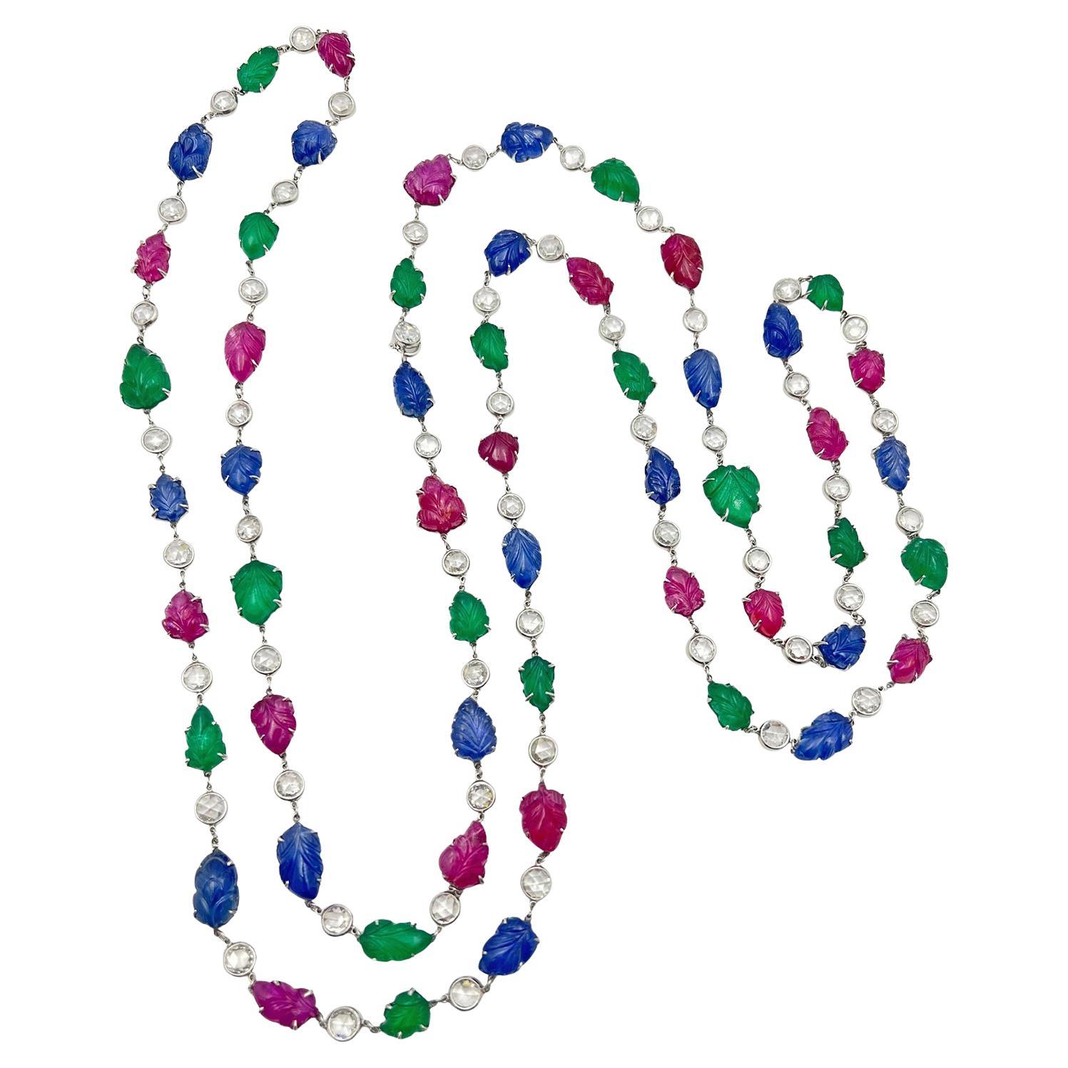 Collar largo de cadena estilo Tutti frutti, de platino, engastado con rubíes naturales, zafiros azules y esmeraldas talladas en forma de hojas, alternados con diamantes redondos talla rosa engastados en bisel. 18 esmeraldas, 18 rubíes y 18 zafiros