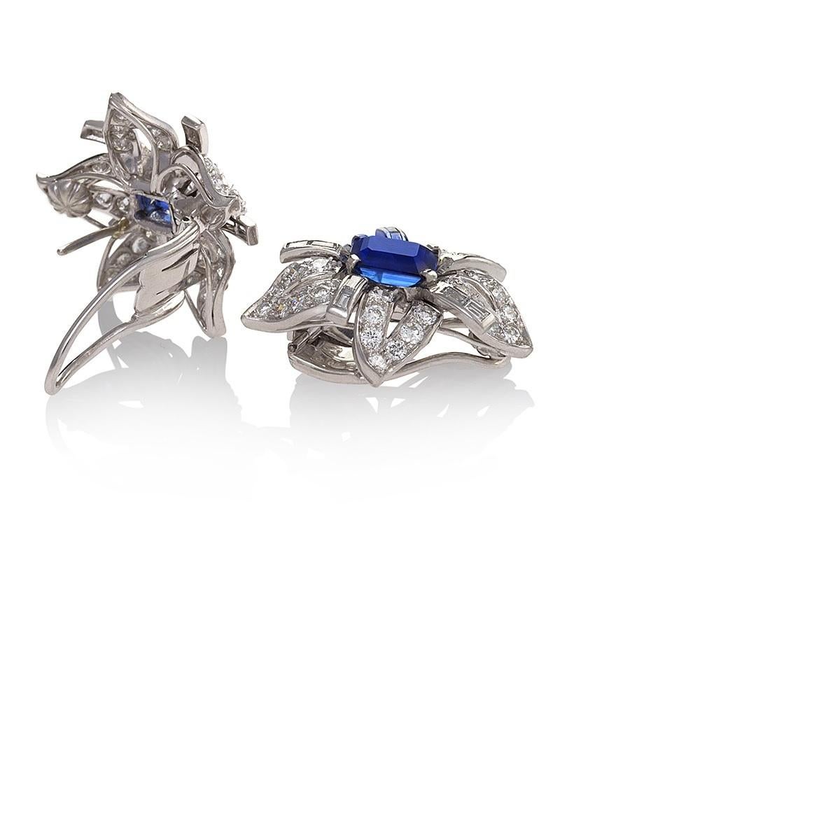A pair of Mid-20th century platinum, sapphire and diamond flower earrings. The floral form earrings are set with 2 rectangular-cut natural untreated sapphires with an approximate total weight of 4.40 carats, framed by petals further enhanced by 20