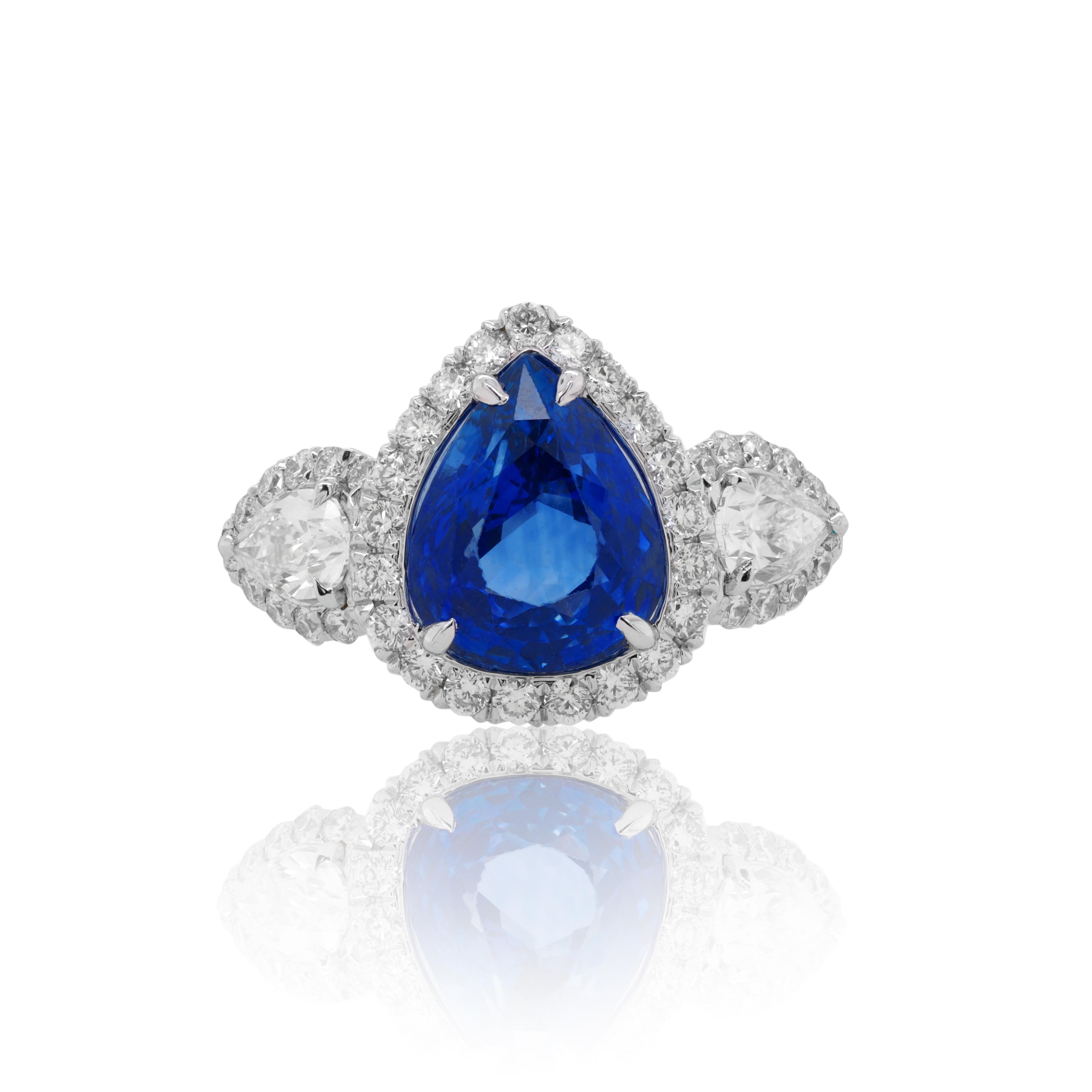Platinum sapphire and diamond ring, features 3.15 blue sapphire pear shape set with two pear shapes  into halo like setting with total 1.20ct of diamonds.
