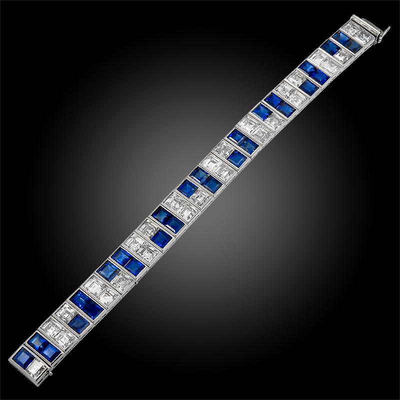 Comprising a double straight line platinum bracelet from the 1960s, crafted with a myriad of square shaped diamonds and sapphire set in a sleek geometric design. Dimensions approx. 7″ long x 1/2″ wide.