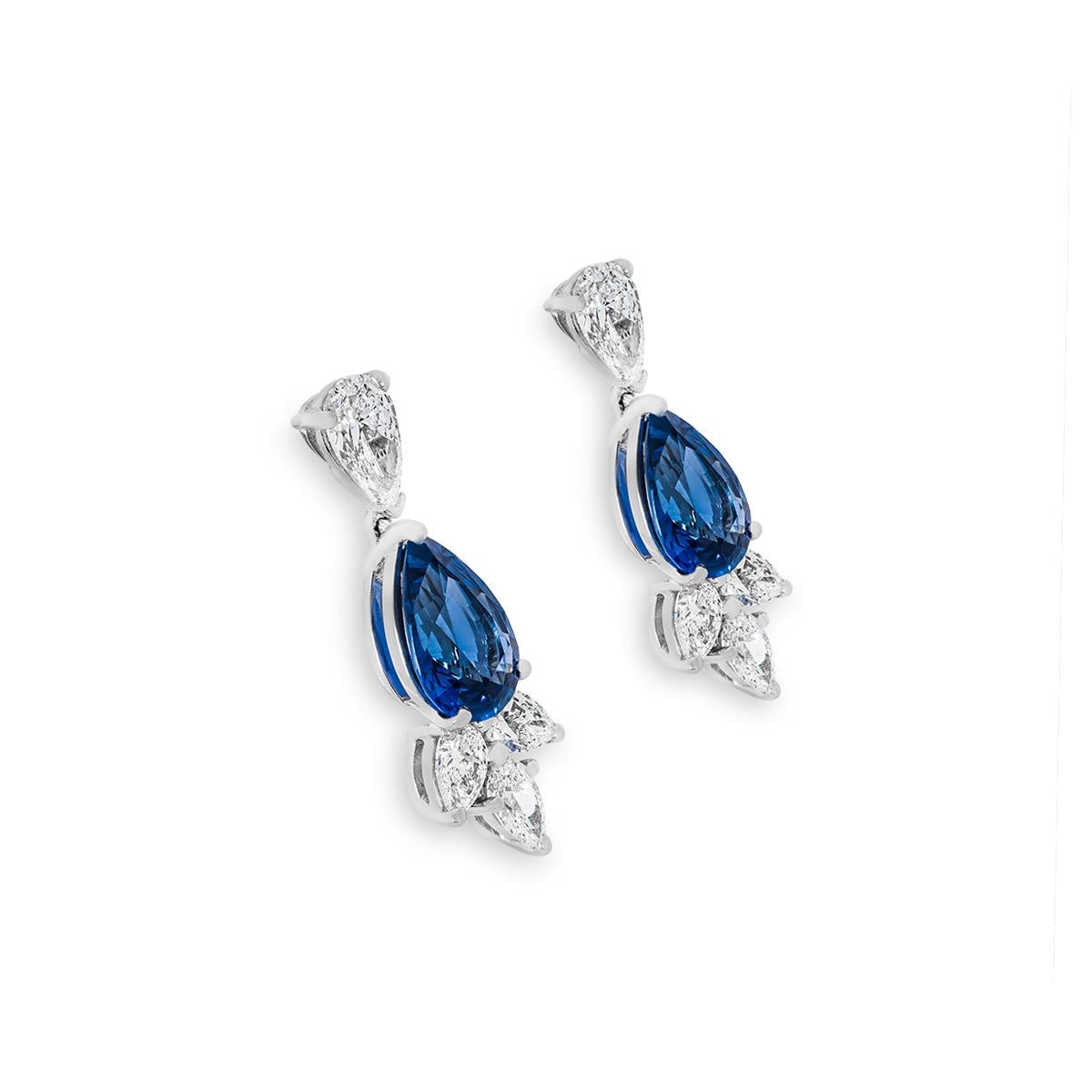 A regal pair of platinum sapphire and diamond drop earrings. Set to the centre of the earrings are pear cut sapphires with an approximate total weight of 3.67ct and displaying a velvety blue hue. Complementing each sapphire is a single pear cut