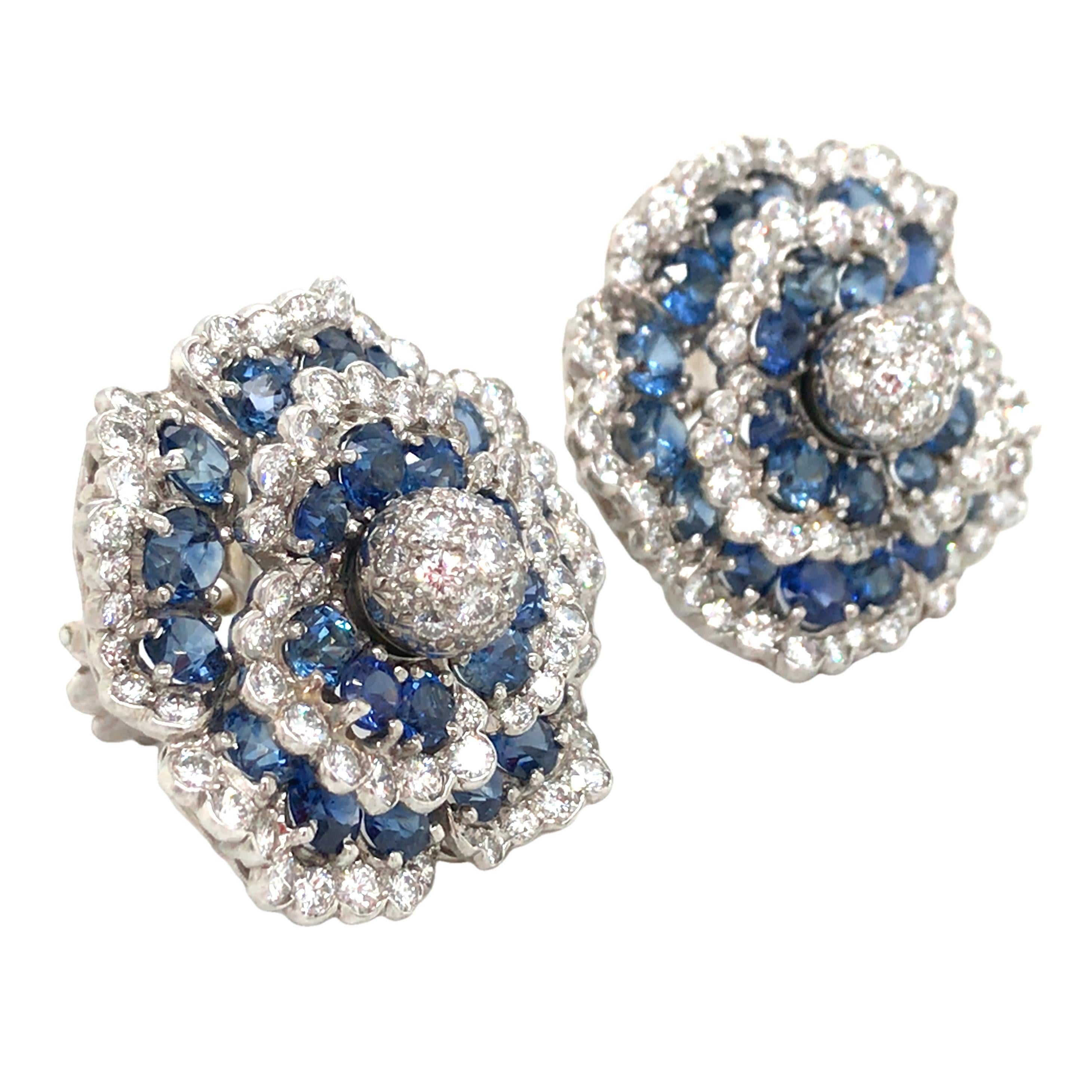 These exquisite earrings stand out with their delicate design and elegant style. Each flower is centered with sparkling diamonds, surrounded by captivating blue sapphires, creating a mesmerizing deep blue glow. With approximately 10.5 carats of blue
