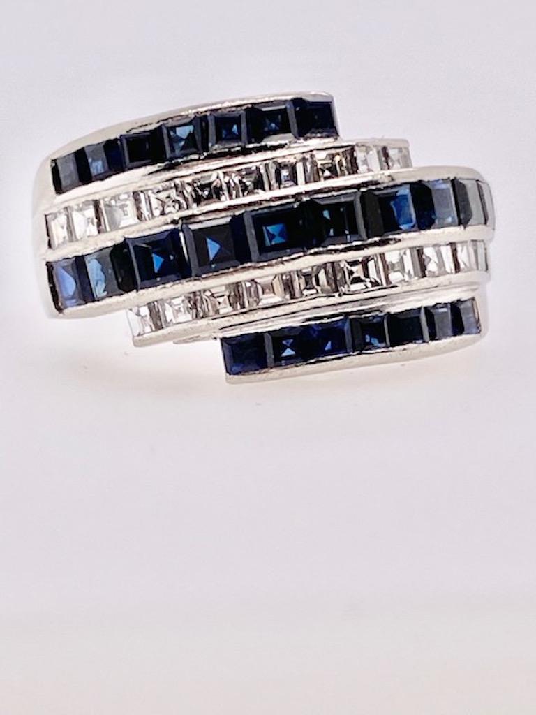Very attractive wrap ring.  Three rows of square cut sapphires intersect with two rows of french-cut diamonds.  Set in a heavy gauge platinum mounting.  Slightly domed shape.   Size 6 and can be custom-sized.  Smart retro look.

Alice Kwartler has