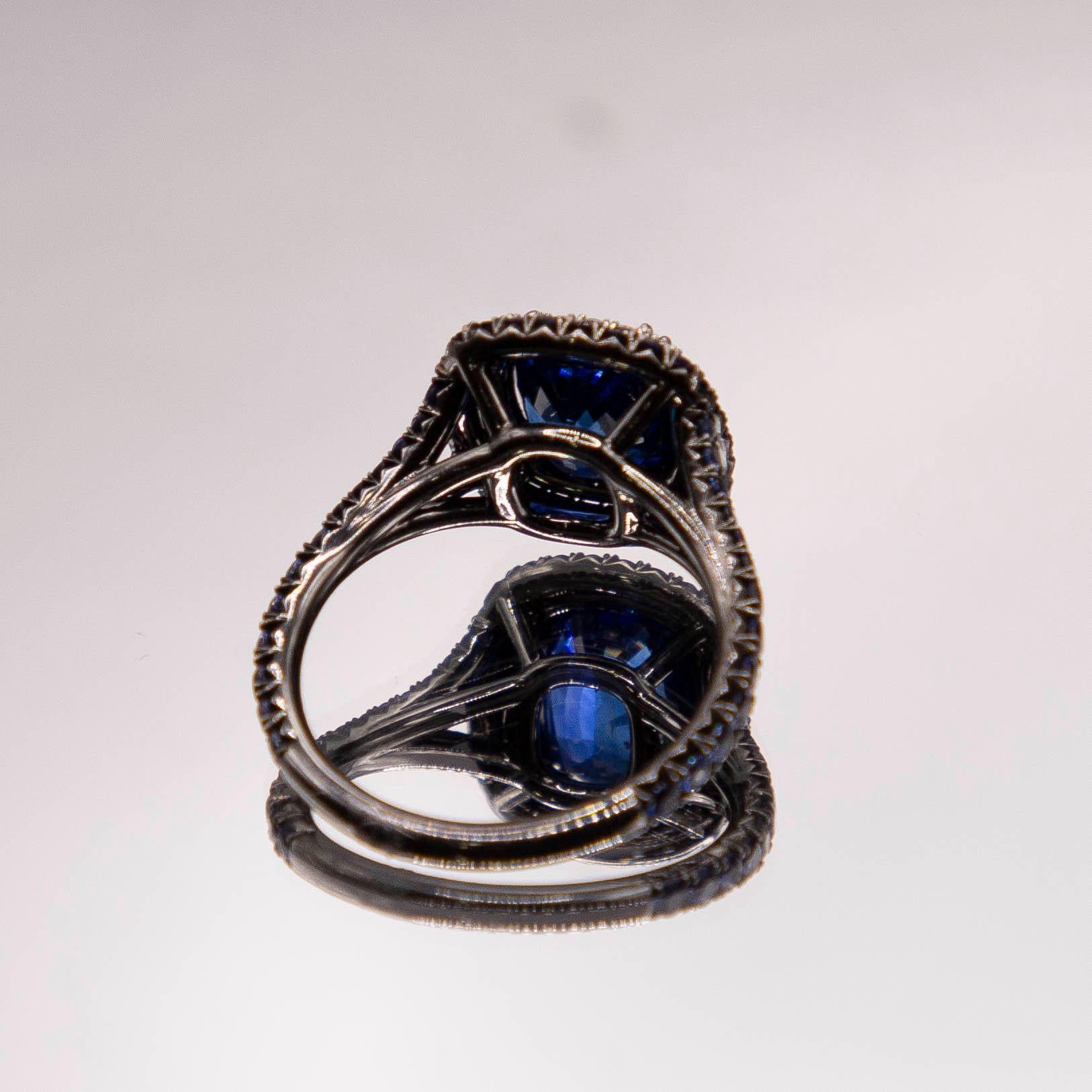 A vivid blue 2.77 carats Ceylon Sapphire of incomparable color, radiates in talon prongs, framed in a halo encrusted with virtually flawless E color diamonds. A slightly recessed secondary halo contains equally spectacular blue round sapphires,