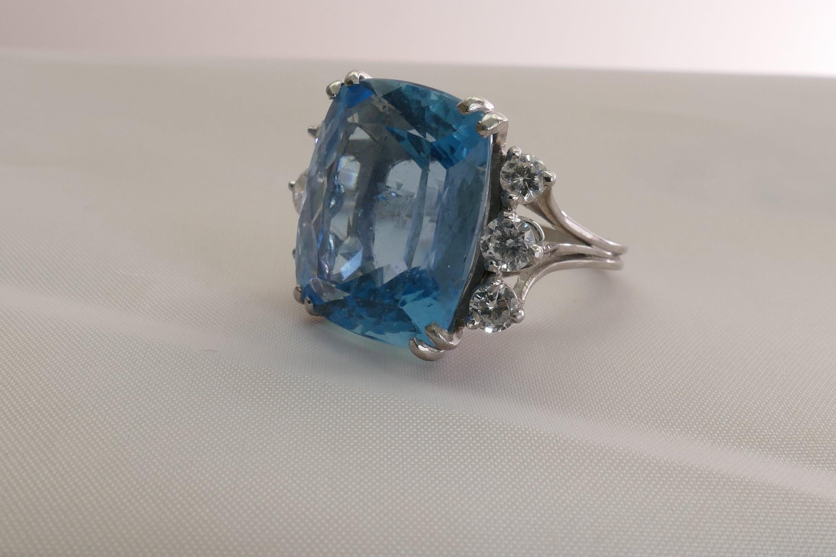 Cushion Cut Aquamarine Ring, 4 split claw set in Platinum with 6 Round Brilliant Cut Diamonds claw set on triple split shoulders to a 2mm shank. The Stone is an Excellent Blue Colour with one inclusion visible to the naked eye.
6 Diamonds close to 1