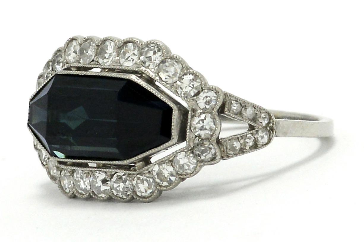 The Eagan shield cut sapphire and diamond Art Deco engagement ring is brilliantly unique. Featuring a striking east to west orientation and a sizable, 4.59 carat sapphire that brings forth a profound, dark velvety blue color. Hand fabricated of