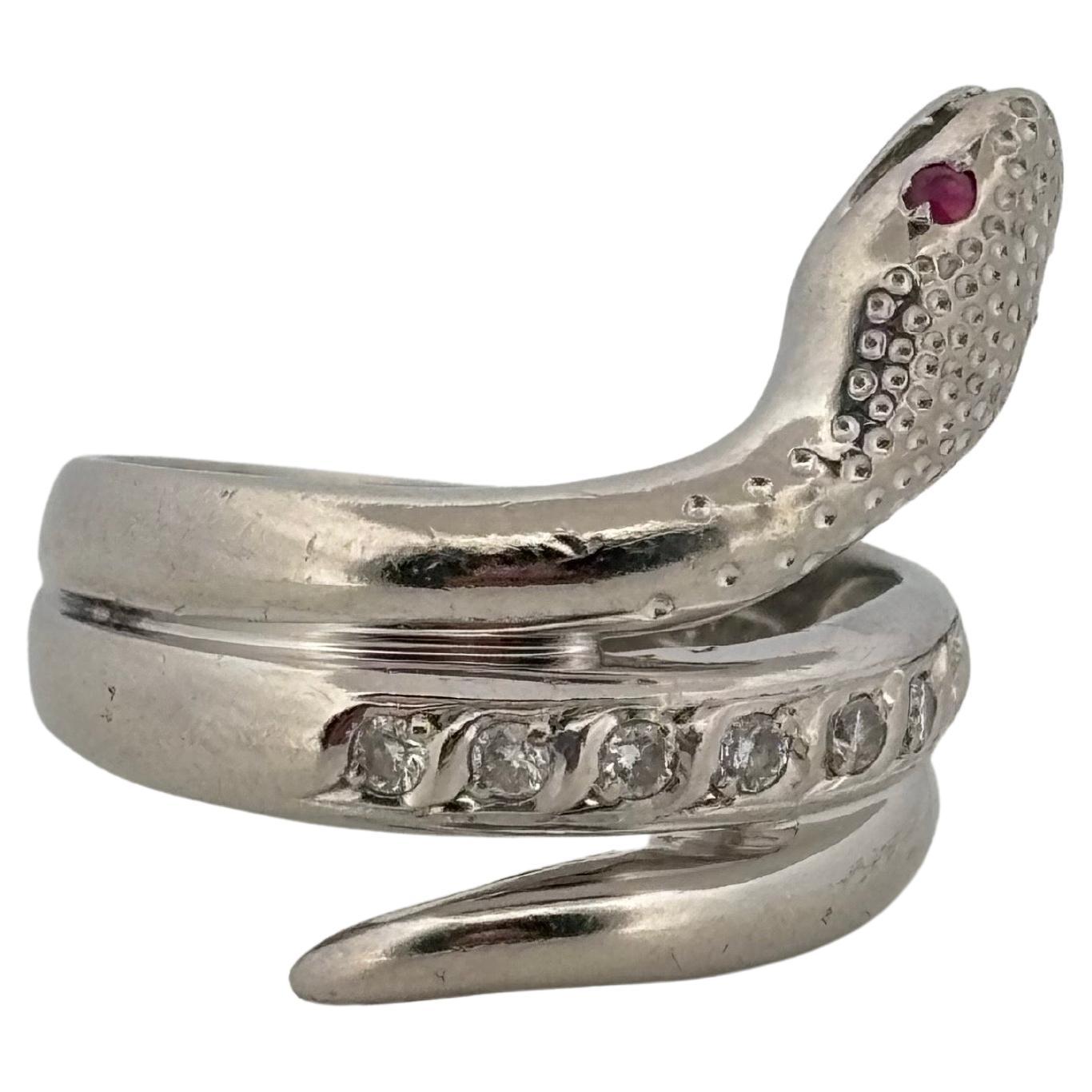 Cette remarquable bague serpent en platine est réalisée en PT900 et présente un motif captivant symbolisant la transformation et la protection. Le corps sinueux du serpent s'enroule gracieusement autour du doigt, rehaussé d'une rangée de diamants