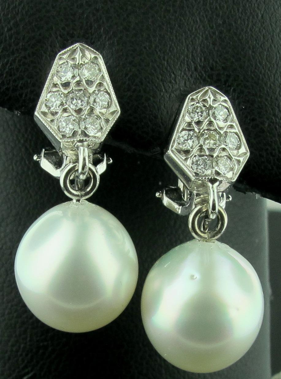 Set in Platinum are 14 round brilliant cut diamonds weighing 0.50 carats in a Shield shape with two white South Sea pearls measuring 13.5mm. Pearls are detachable. Pierced omega backs. 
