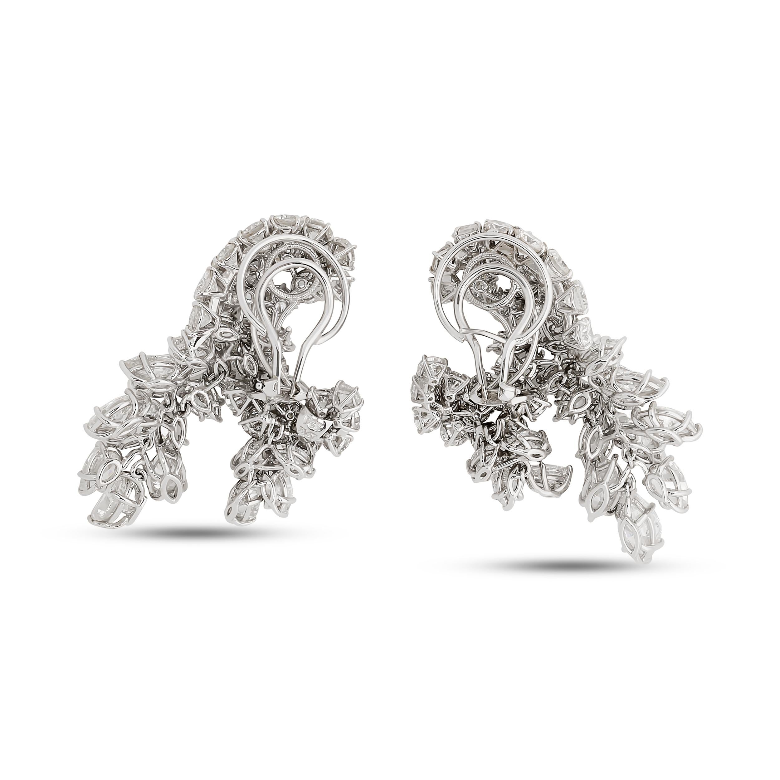 Ces remarquables boucles d'oreilles en platine présentent un design dynamique en forme de grappe, avec des diamants ronds de taille brillant, des diamants en cascade de taille marquise et des diamants en forme de poire, créant ainsi une déclaration