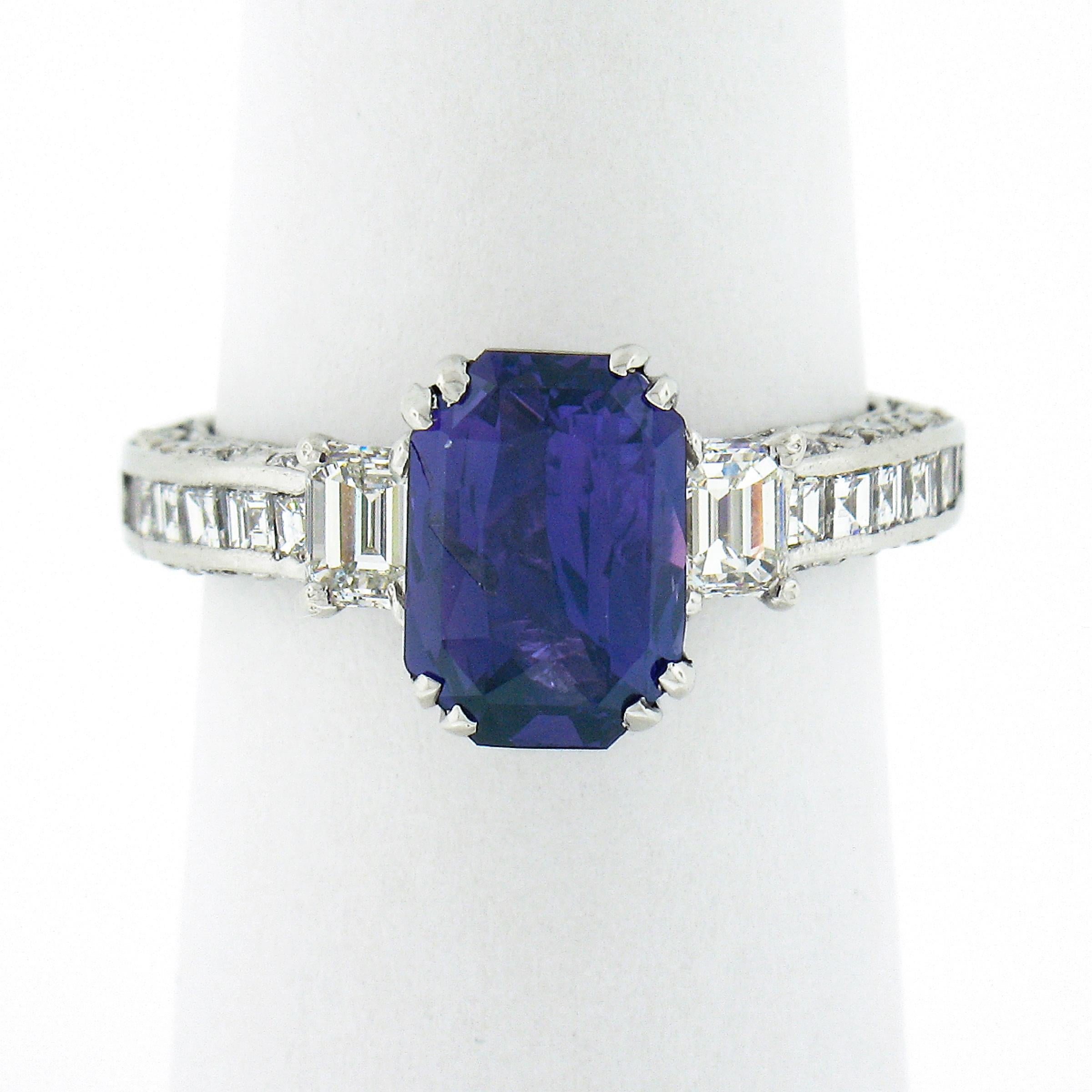 This magnificent and very chic cocktail or engagement style ring is crafted in solid platinum and was designed by Tacori. It features a truly breathtaking, GIA certified, emerald cut sapphire solitaire neatly dual prong set at its center. The stone