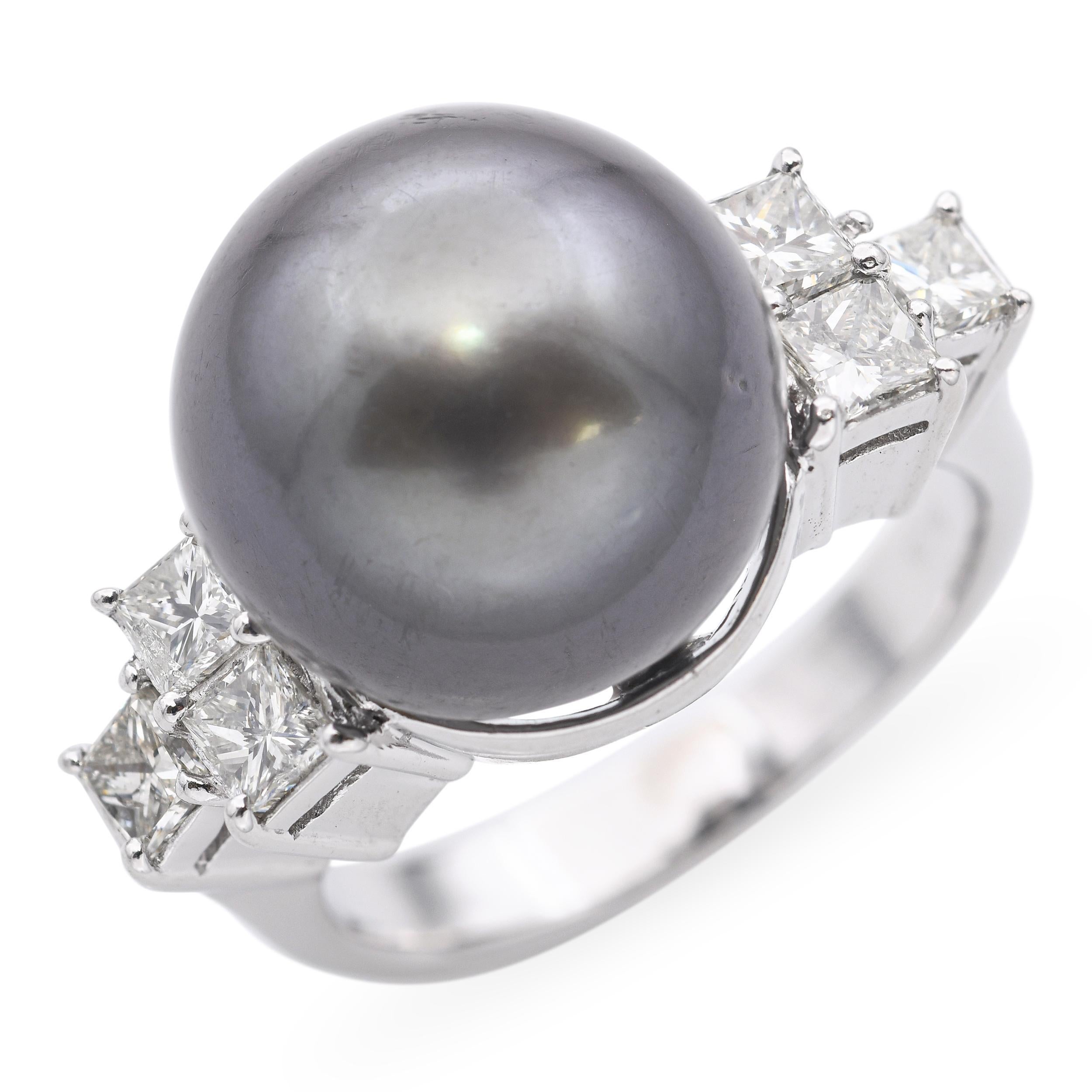Questo sofisticato anello è realizzato in platino e mette in mostra una luminosa perla di Tahiti al centro, nota per la sua ricca lucentezza naturalmente scura con sottili sfumature di verde, grigio e pavone. Accanto alla perla ci sono 1,01 carati