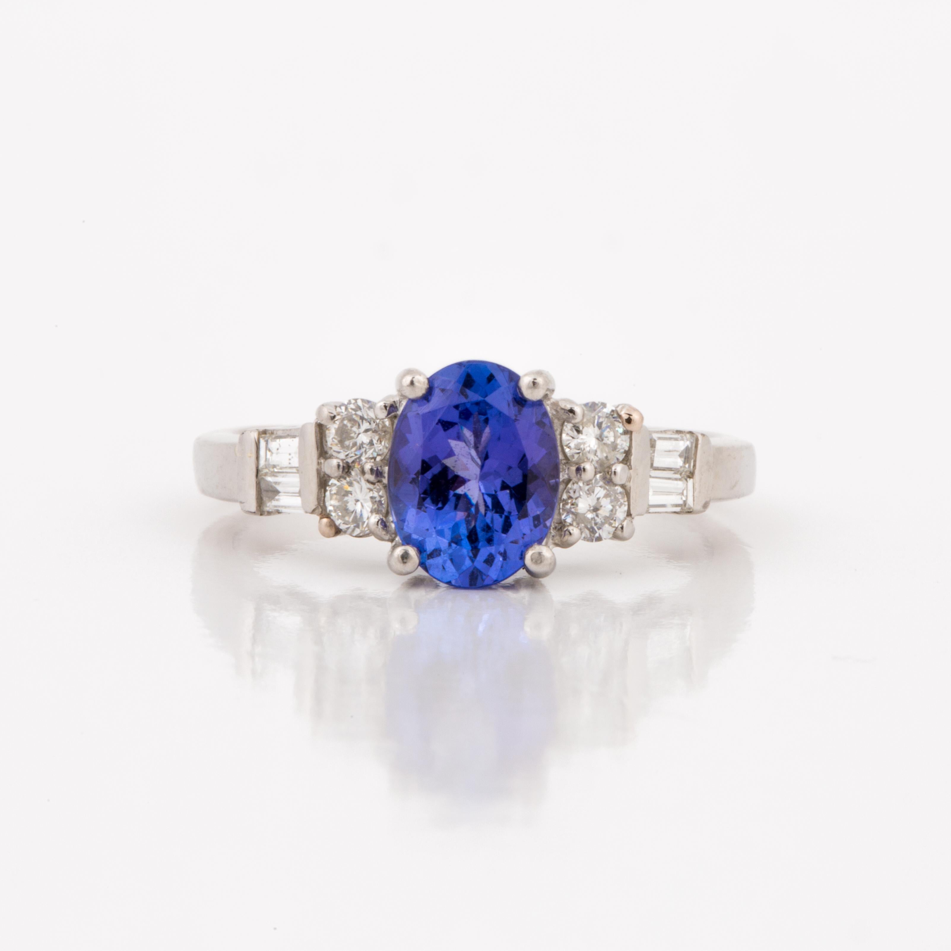 Ring set in platinum holds a 1.75 carat oval Tanzanite.  In addition, there are four (4) round diamonds and four (4) baguette diamonds totaling 0.55 carats; they are H-I in color and VS-SI in clarity.  Ring is currently a size 6-1/2.  Measures 5/8