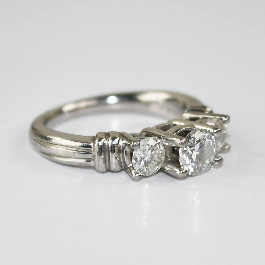 Ladies' platinum and diamond engagement ring.
Stamped 950 Plat, 1 1/2 tw, and weighs 10.5 grams gross weight.
The three diamonds are round brilliant cuts, approximately .67 center diamond with two smaller side diamonds, .1.50 total carats, H to I