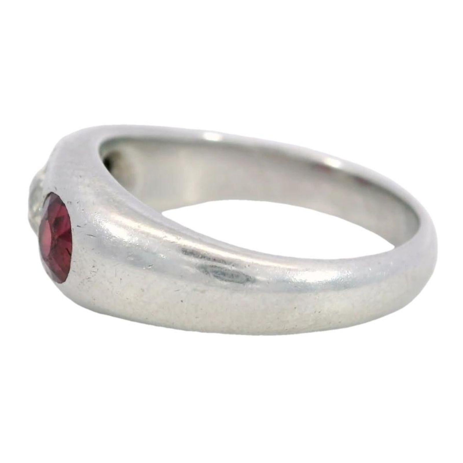 Anello gitano in platino con tre pietre, rubini e diamanti al centro, in stile tardo-decò anni '50

Elegante e sofisticato, questo anello gitano in platino è uno studio di design raffinato. Realizzato con una fascia liscia e lucida, ha un peso di