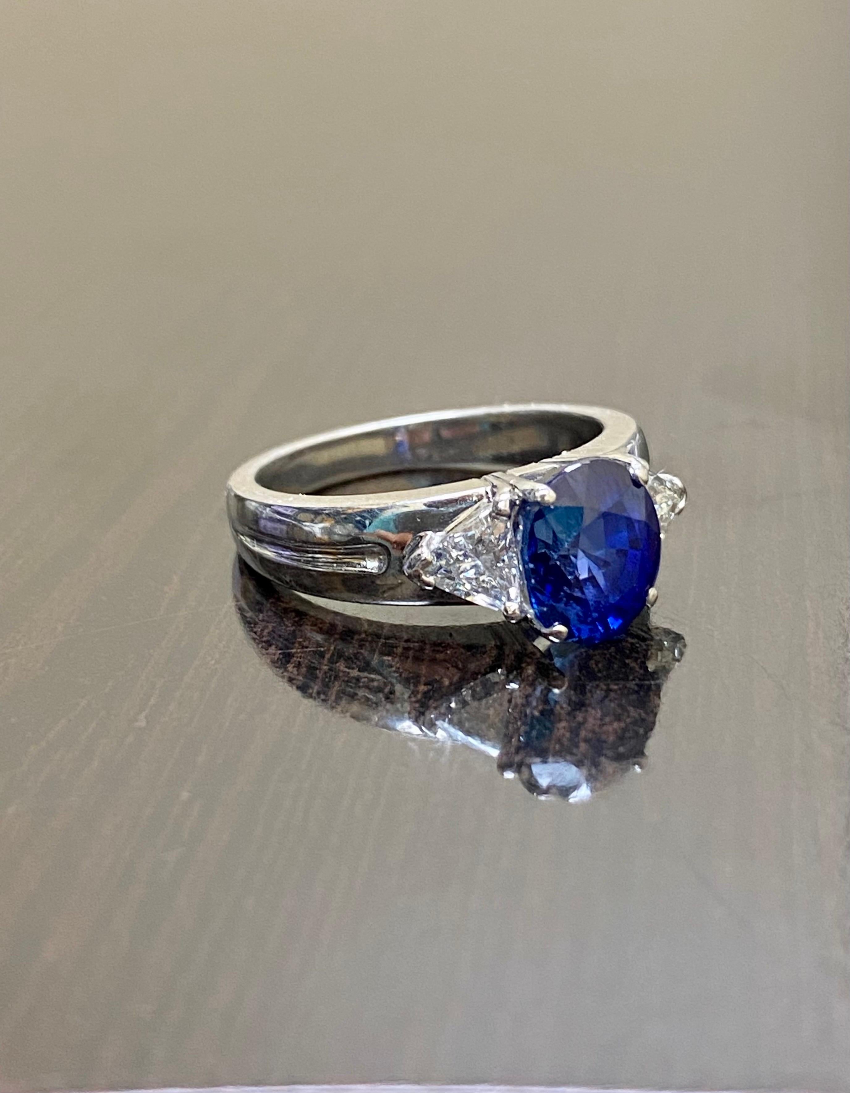 Oval Cut Platinum Three Stone Trillion Diamond 4.10 Carat Blue Sapphire Engagement Ring For Sale
