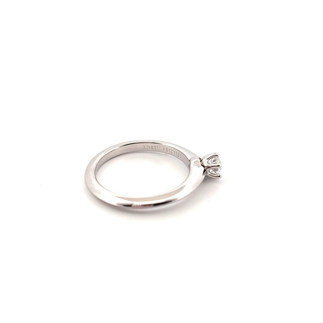 Dieser elegante Verlobungsring von Tiffany & Co. verkörpert zeitlose Raffinesse in ihrer reinsten Form. Der aus luxuriösem Platin gefertigte Ring enthält einen runden Diamanten im Brillantschliff von 0,18 Karat, der mit bemerkenswerter Klarheit und