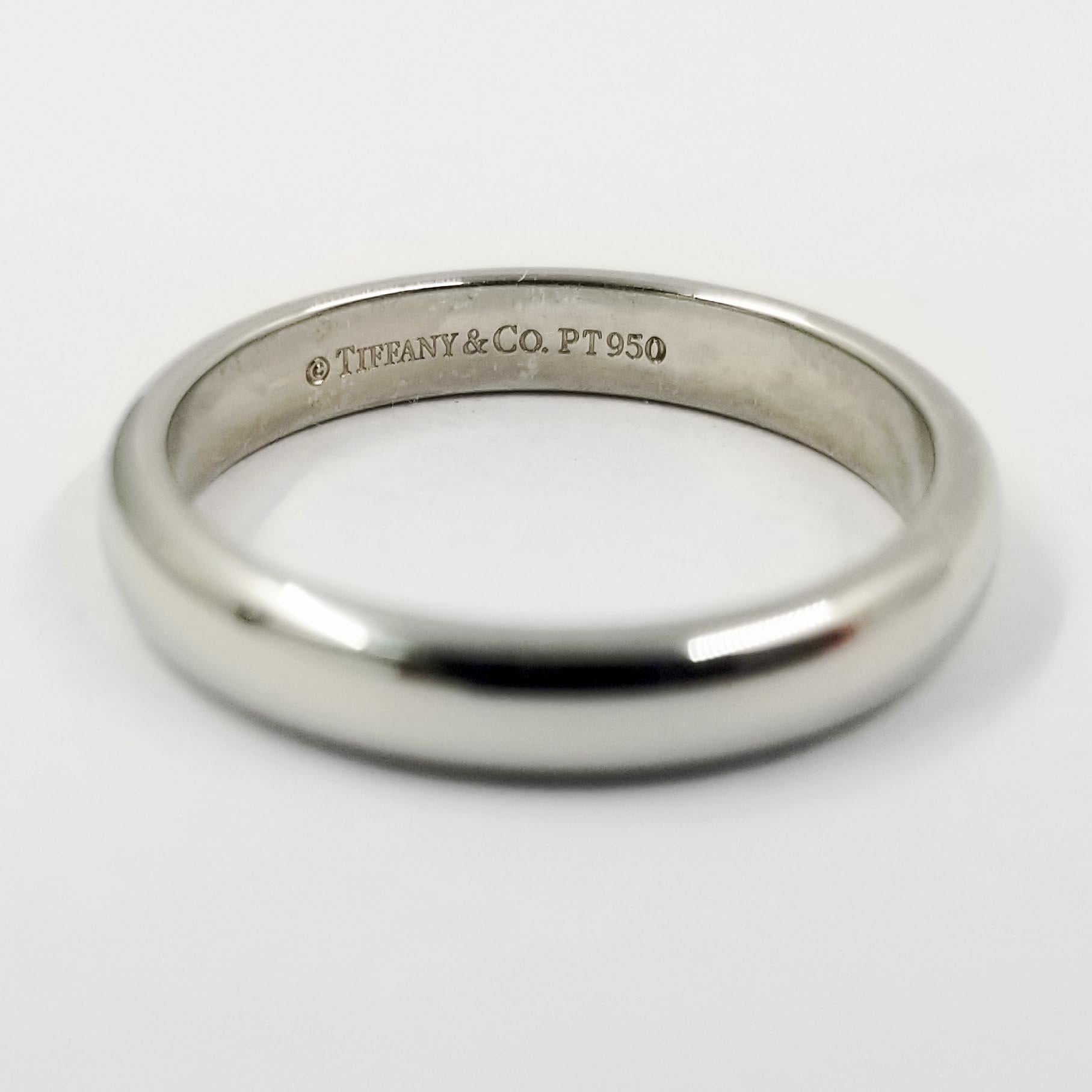 This simple half round wedding band from Tiffany & Co is crafted in platinum with a high polish shine. The interior is stamped PT950. Width is approximately 3.1 millimeters. Current finger size is 5.5; purchase includes free sizing (up or down 1