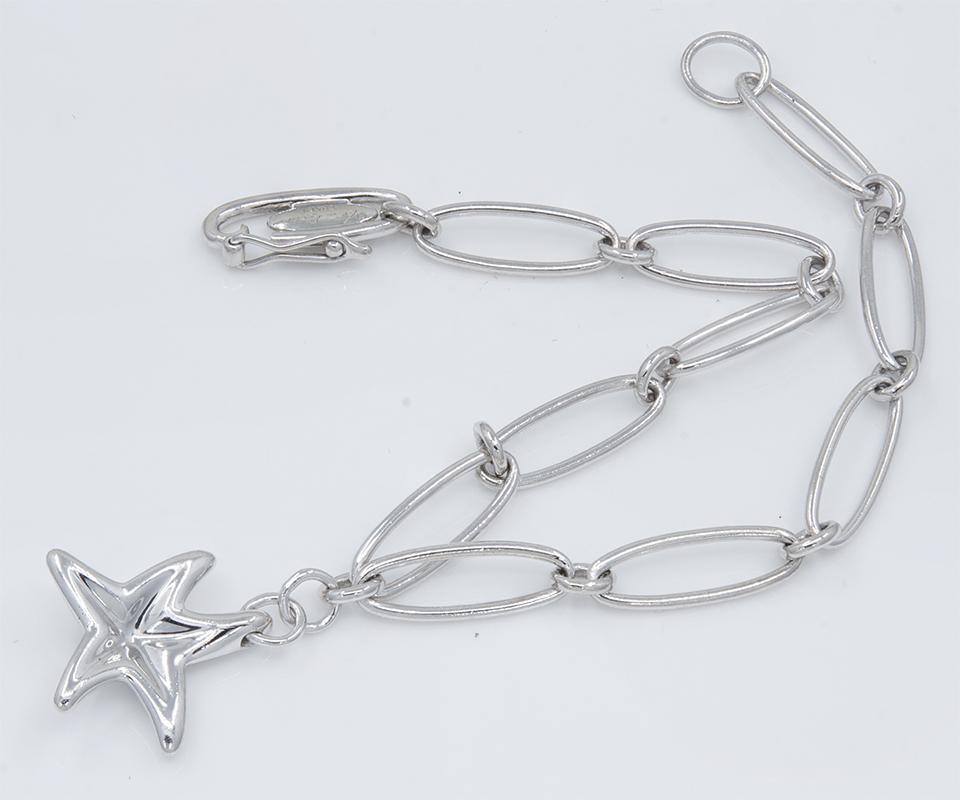 Lovely platinum charm bracelet.  Made and signed by Elsa Peretti for TIFFANY & CO.  Graceful oval links, with a figural 