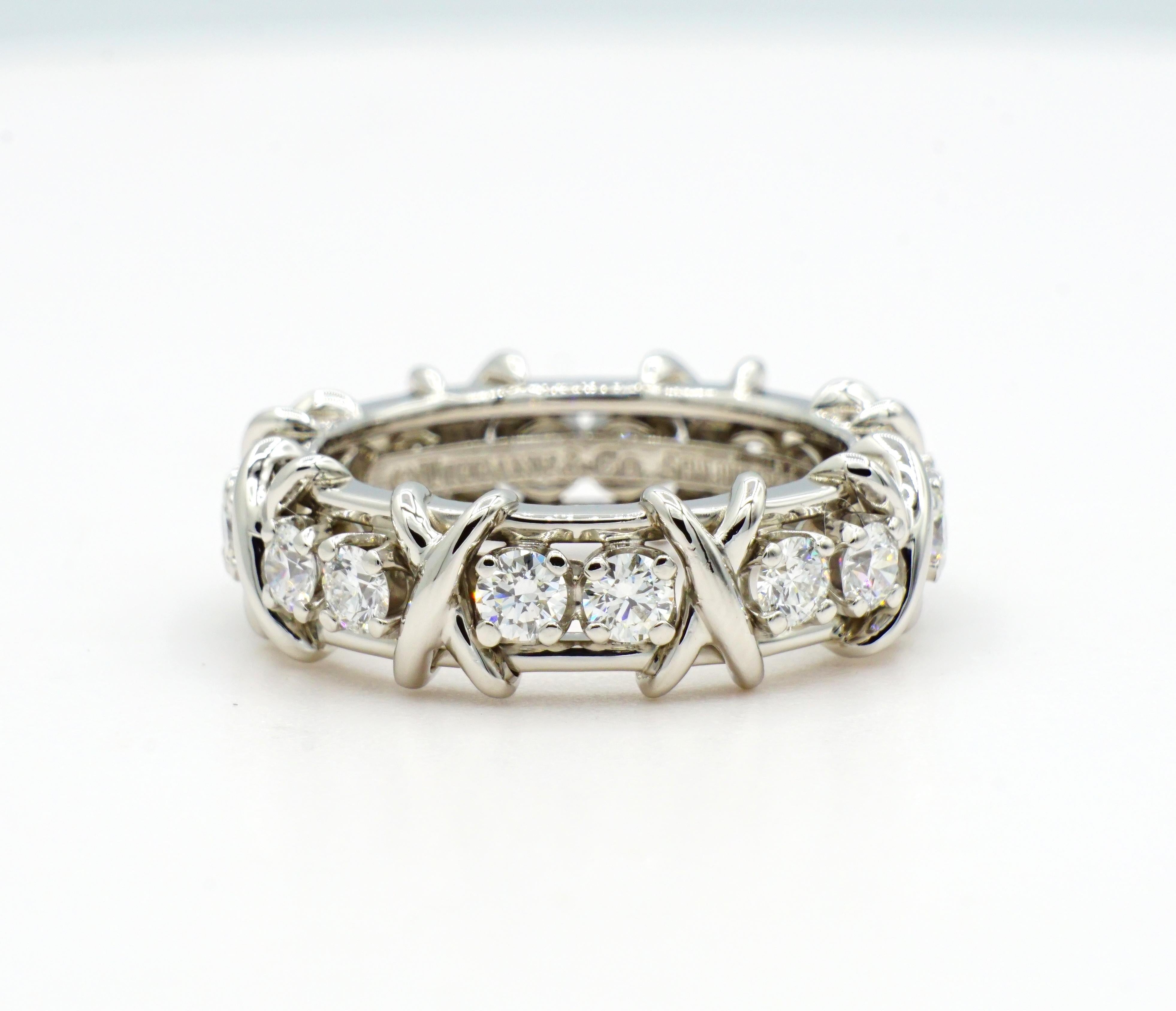 Platinum Tiffany & Co. Schlumberger X Sixteen Stone Diamond Eternity Ring. This ring is a size 5.5, 6.6m wide, 3.4mm thick, with sixteen prong set round diamonds of approximately 1.28cttw that are F color and VS2 in clarity. Overall, this ring is in