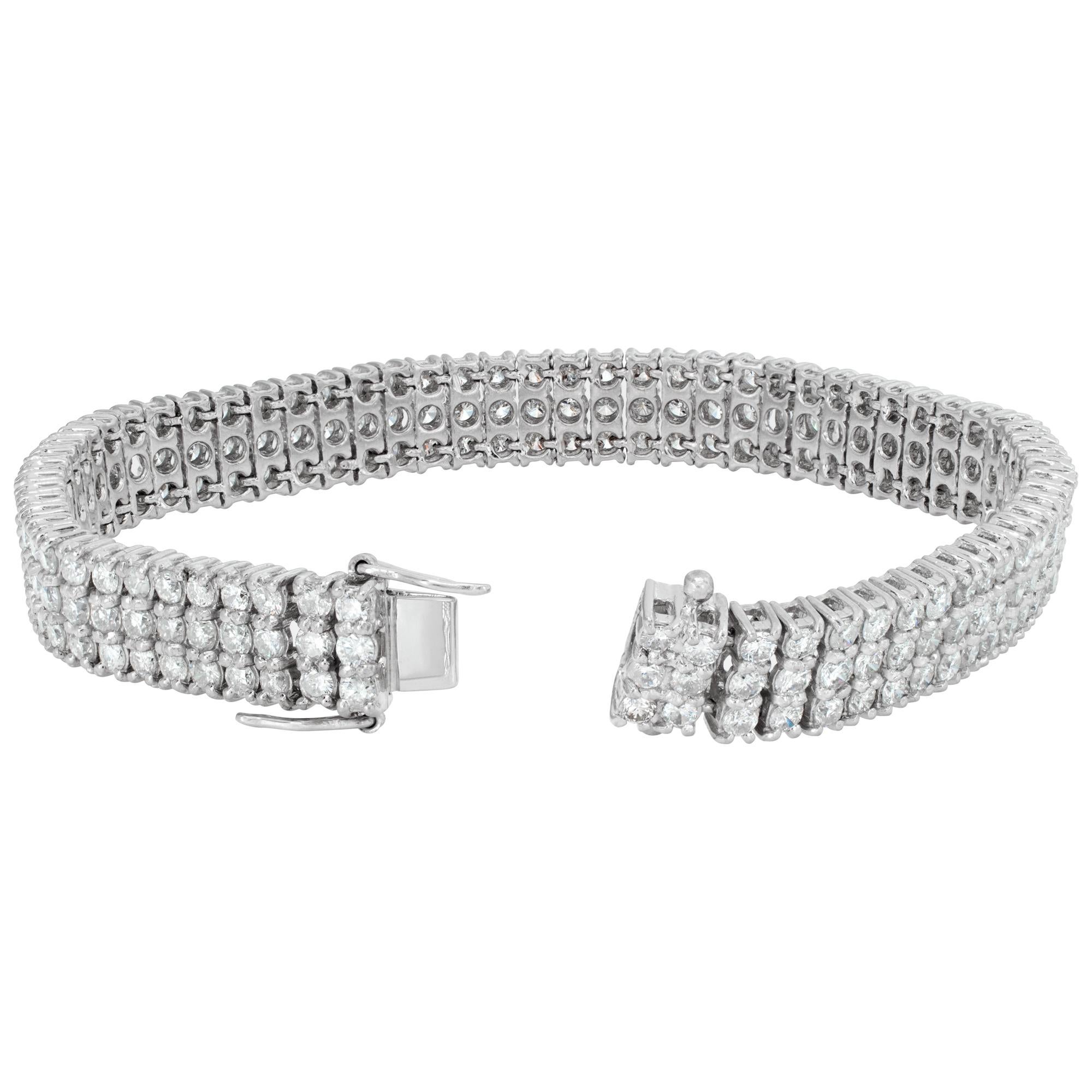Triple row diamond line bracelet in platinum with approximately 10 carats in round cut diamonds, H-I color, SI-I1 clarity. Measures 7 inch length, width 9mm.
