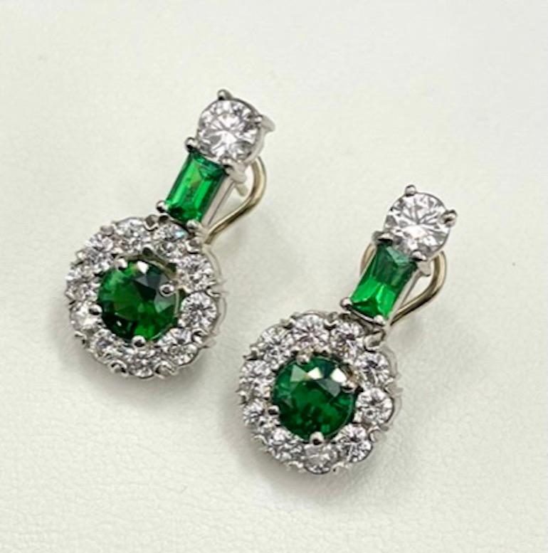 This is a pair of unique and very attractive Tsavorite Earrings. Tsavorites come from the Tsavo Game Reserve in Kenya, Africa, where it was discovered in 1967. The 2 center Round Tsavorites weigh 2.34Ct Total Weight, and the two Baguette Cut