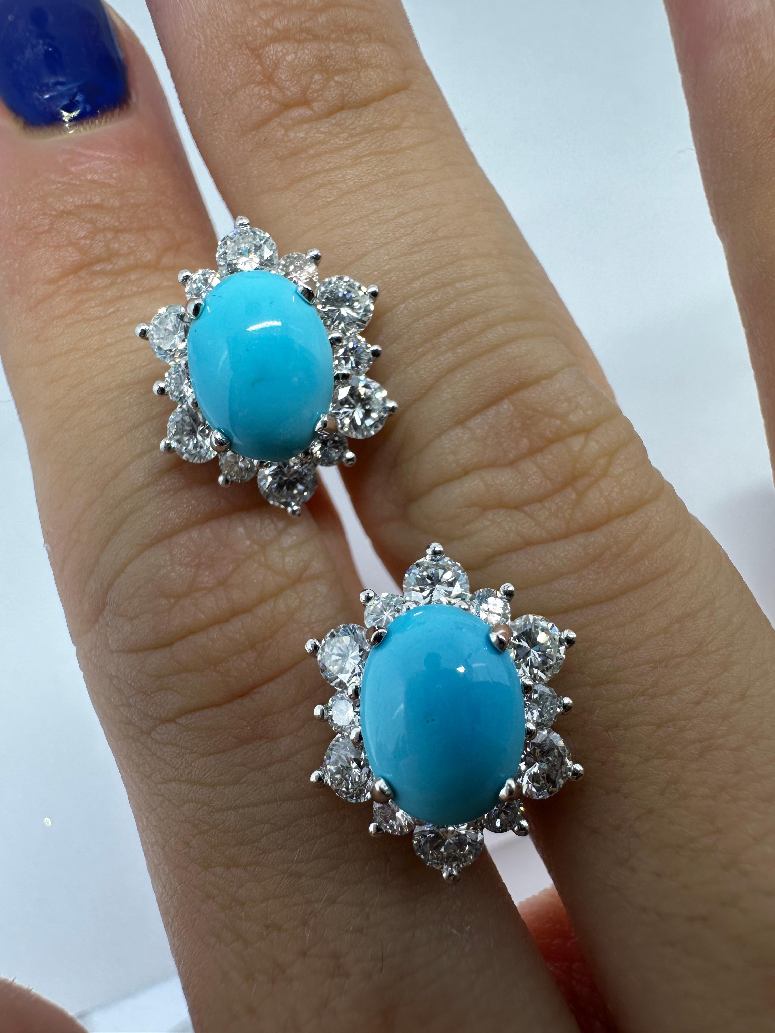 Questi orecchini in platino presentano vibranti cabochon ovali di turchese, ognuno dei quali misura circa 7,27 mm x 9,64 mm, incorniciati da un'aureola di 2,02 carati di diamanti taglio brillante. Realizzati in platino e timbrati PT 900, gli