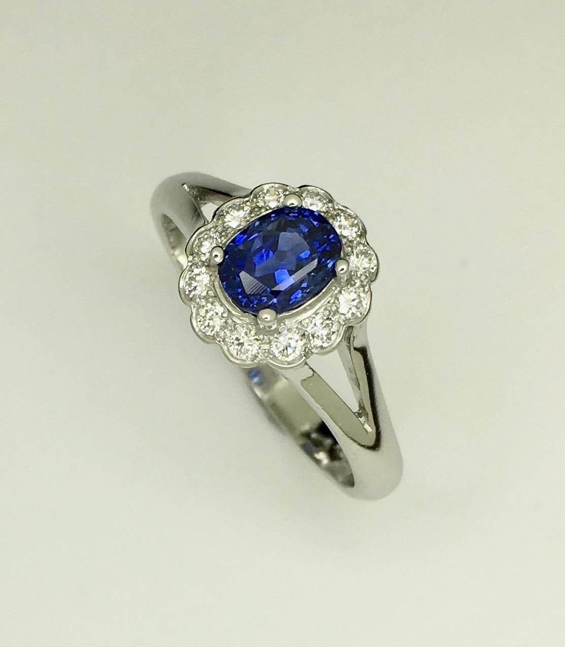 Platinum Untreated Ceylon Sapphire Diamond Cluster Ring

Classic vintage style cluster ring. Center stone is untreated oval blue sapphire set in a four claw setting. Surrounding the blue sapphire is 12 round brilliant cut diamond forming a scallop