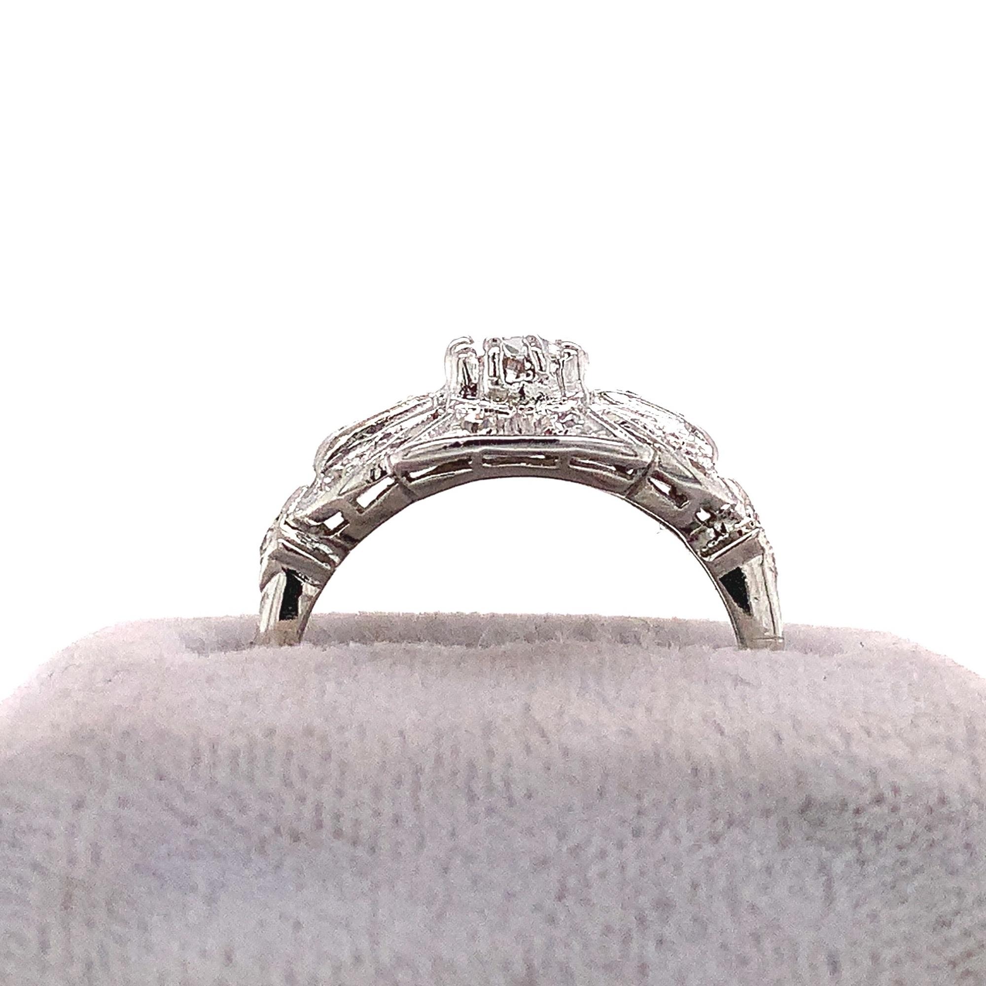 Platinum diamond ring featuring an European cut center diamond measuring about 4.7mm and weighing about 1/3ct. There are 12 round diamond accents measuring 1.3mm to 1.5mm and 2 diamond baguettes weighing about .17cts total. The diamonds have SI