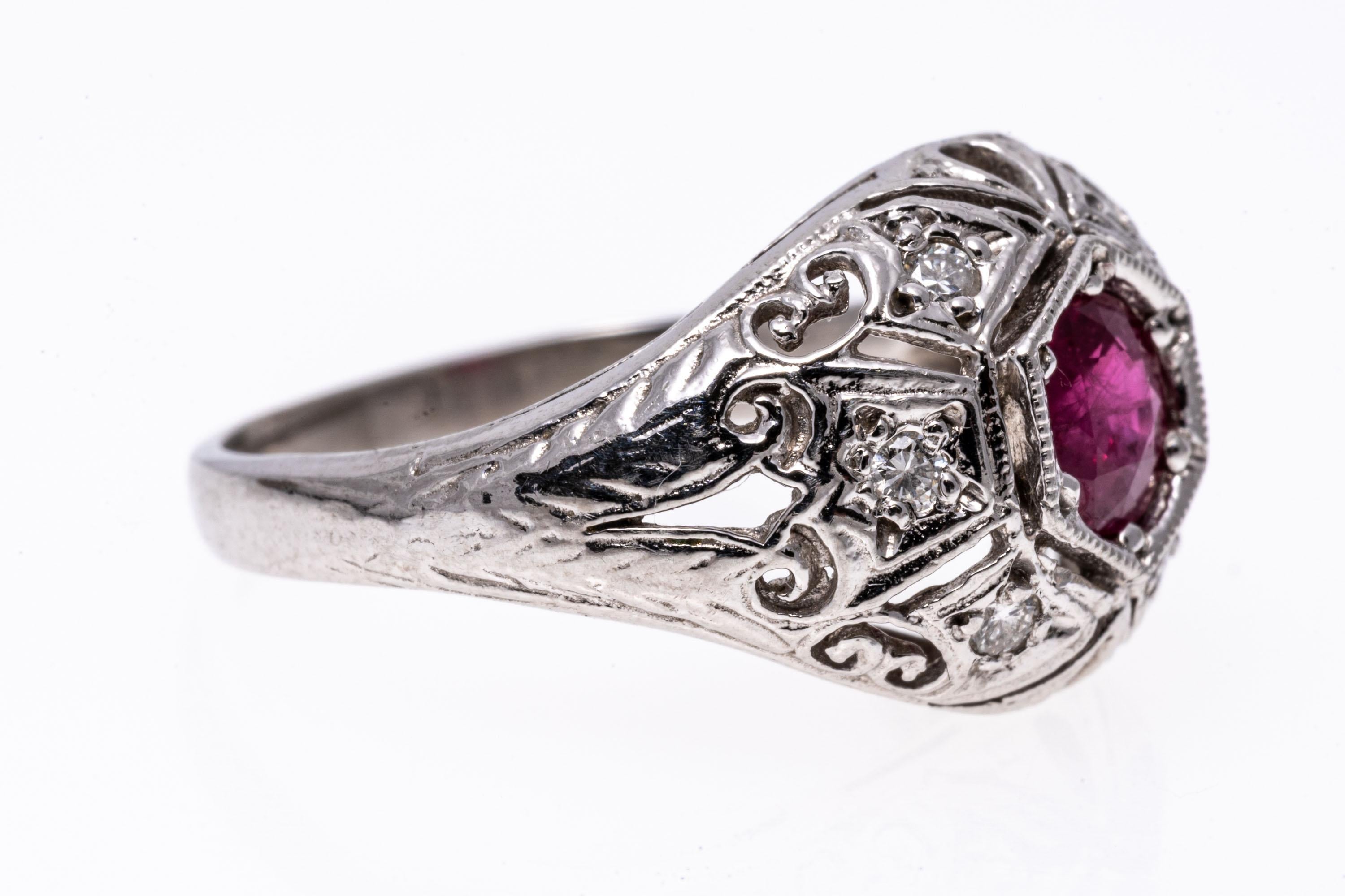 Platinum ring. This beautiful vintage platinum ring is a pierced filigree dome style, set in the center with a round faceted, dark pinkish red color ruby, approximately 0.37 CTS, accented by round faceted diamonds, approximately 0.06 TCW.
Marks: