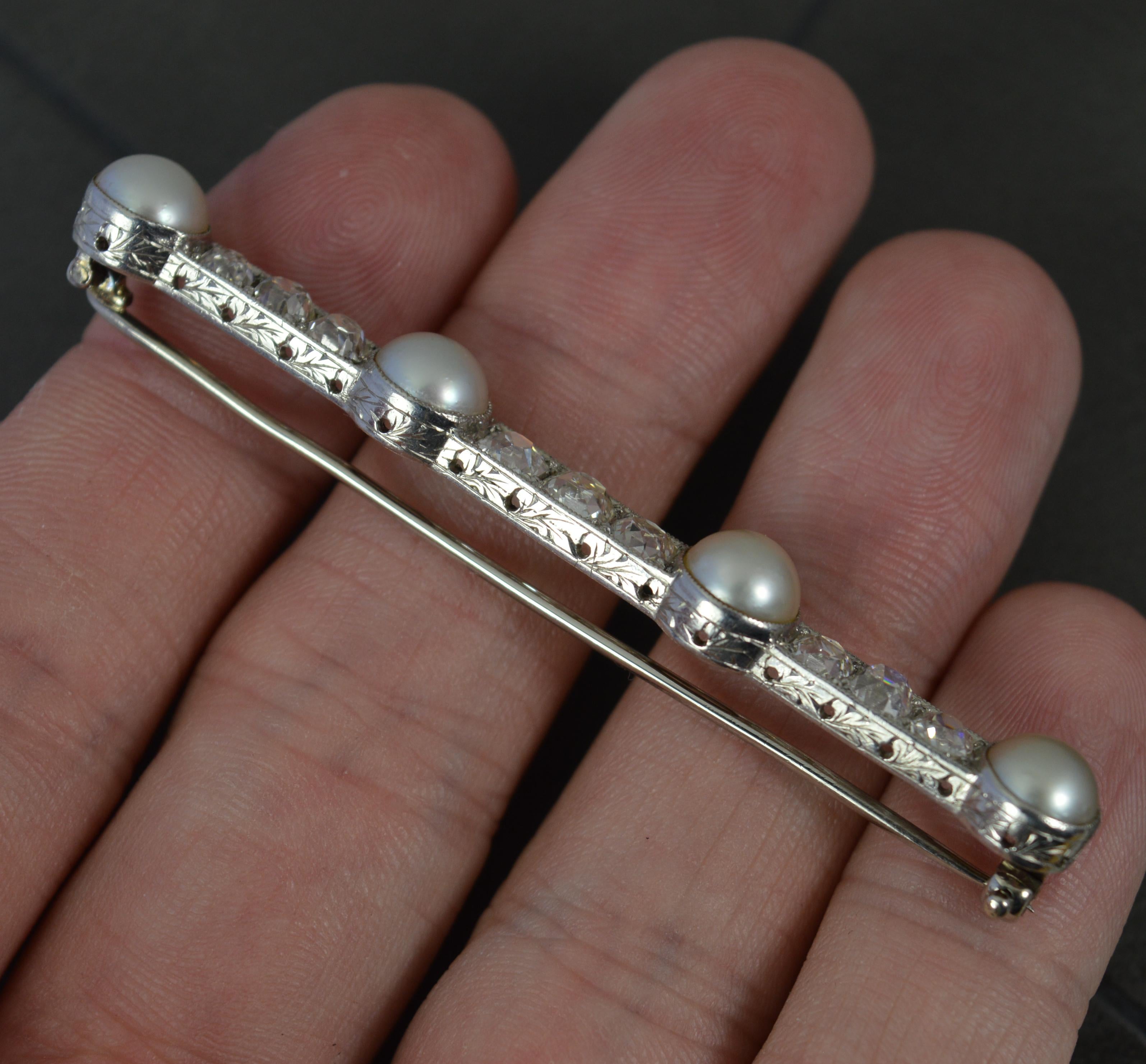 A stunning antique bar brooch, circa 1920.
Solid platinum example with fine engraving to top and bottom of the brooch.
Set with four large pearls with trios of old cushin cut diamonds in between each. The nine diamonds total 2.3-2.5 carats total. Vs