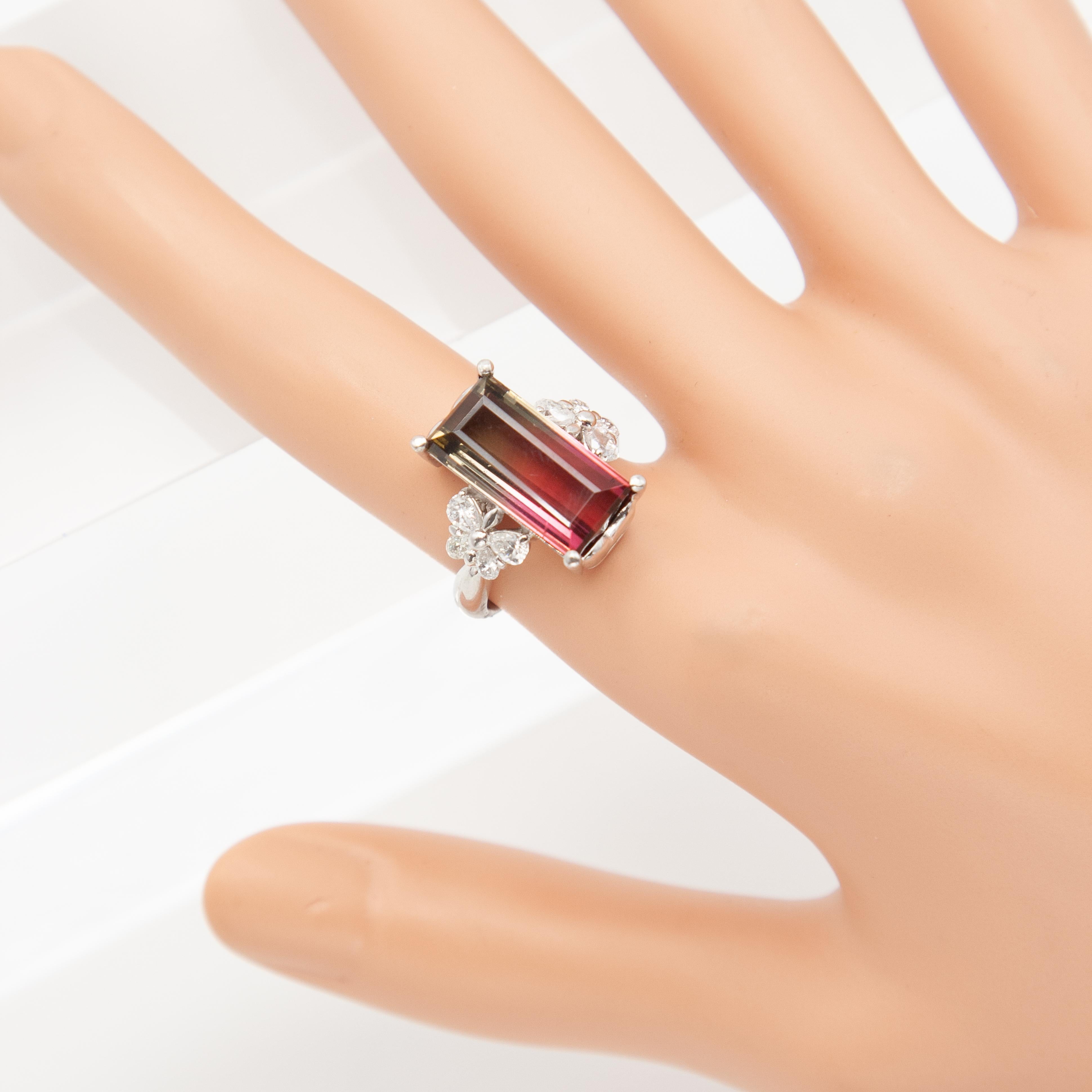 This Stunning platinum ring set with an emerald-cut watermelon tourmaline weighing approximately 7.8 carats, this gem displays the desirable natural transition from deep pink through soft blush to green. The vibrant center stone is flanked on each