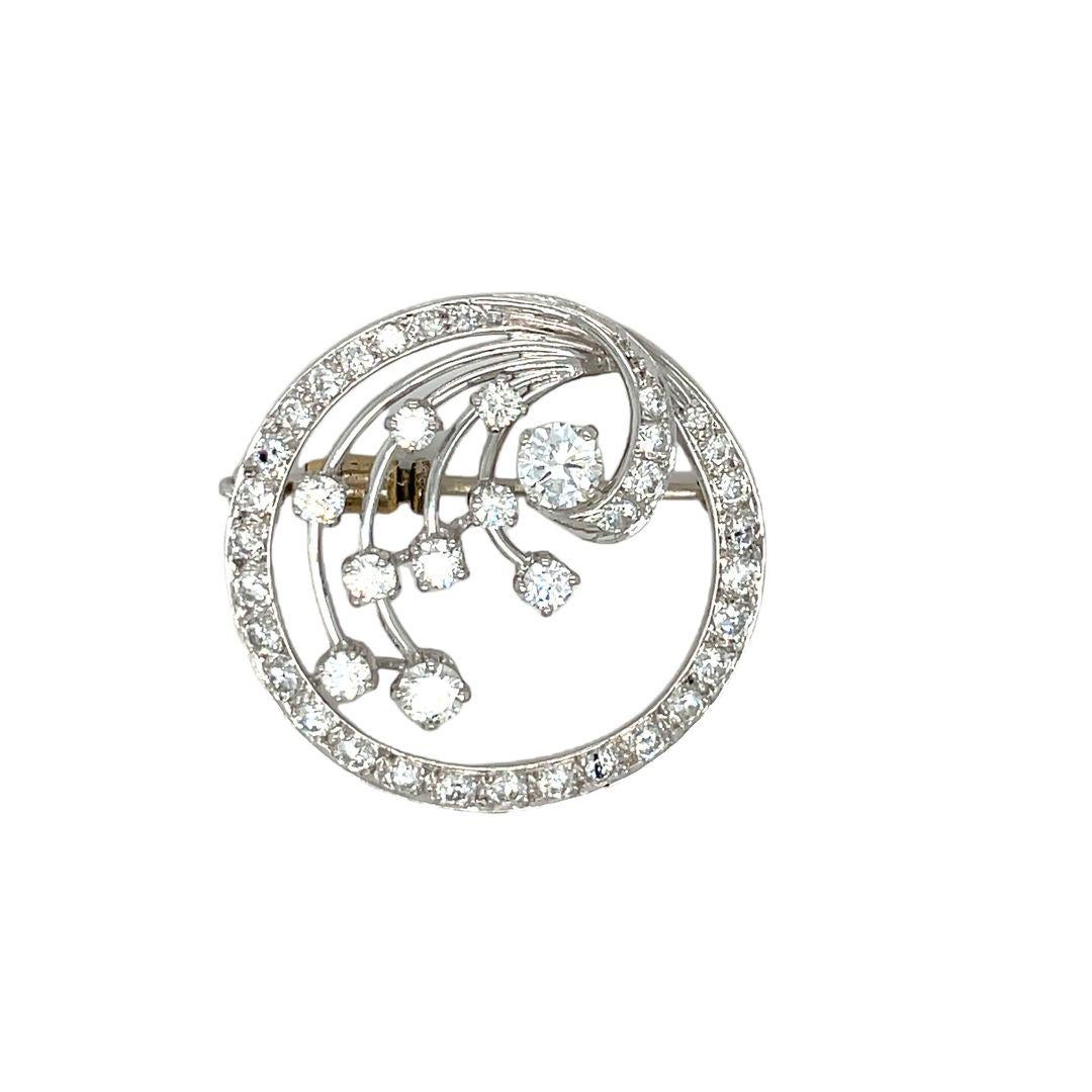 The elegant diamond circle brooch is set in platinum and features a 2.50-carat round-brilliant-cut diamond centerpiece. It has a wave design that gracefully ties into the open-space circle. The circular border holds twenty-eight round brilliant cut