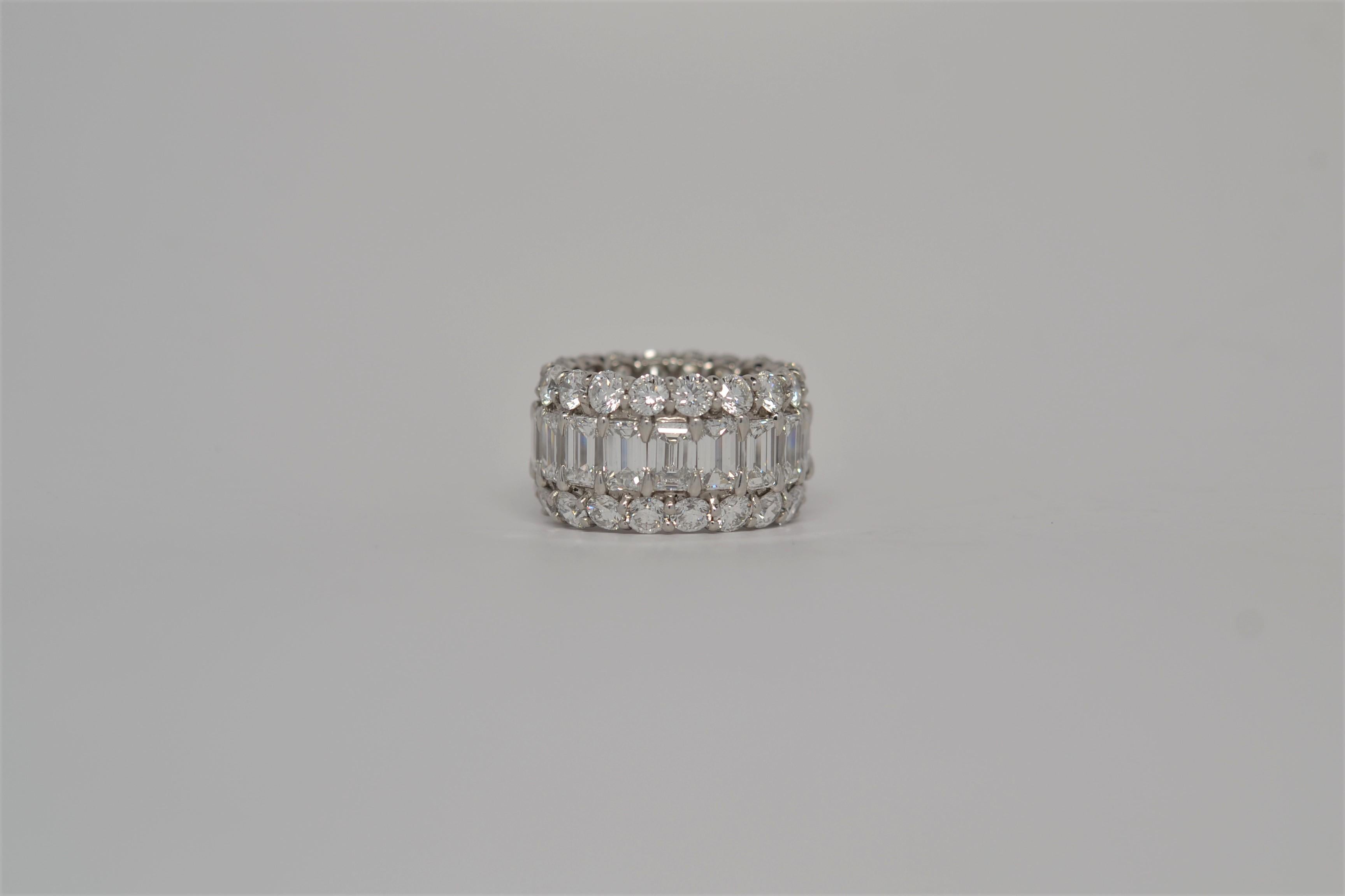 An elegant ladies' Platinum eternity ring set all the way around with Emerald Cut and Round Brilliant Cut Diamonds. The handmade ring uses a three row layout with a center of Emerald Cuts and two rows of Round Brilliant Cut Diamonds. The Emerald Cut