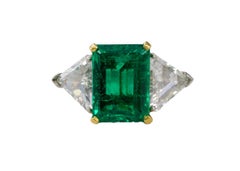 Anello a tre pietre in platino e oro giallo con smeraldo taglio smeraldo e diamante taglio trillion
