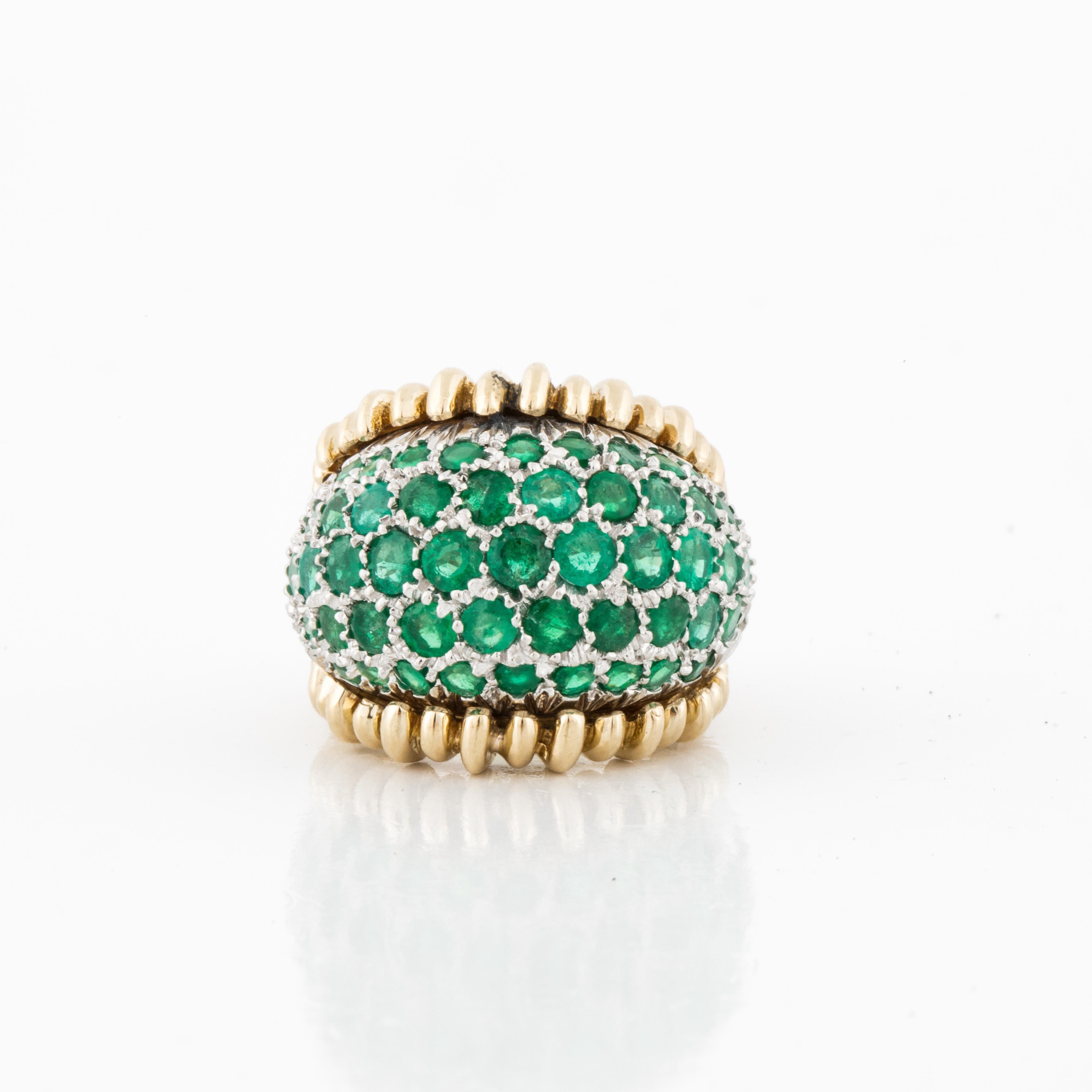 Platinum and 18K yellow gold ring in a bombé dome style with pavé set round emeralds.  There are 55 round emeralds that total 2.25 carats.  The ring is currently a size 4 1/4.  It measures 7/8 of an inch by 3/4 of an inch and stands 3/8 of an inch
