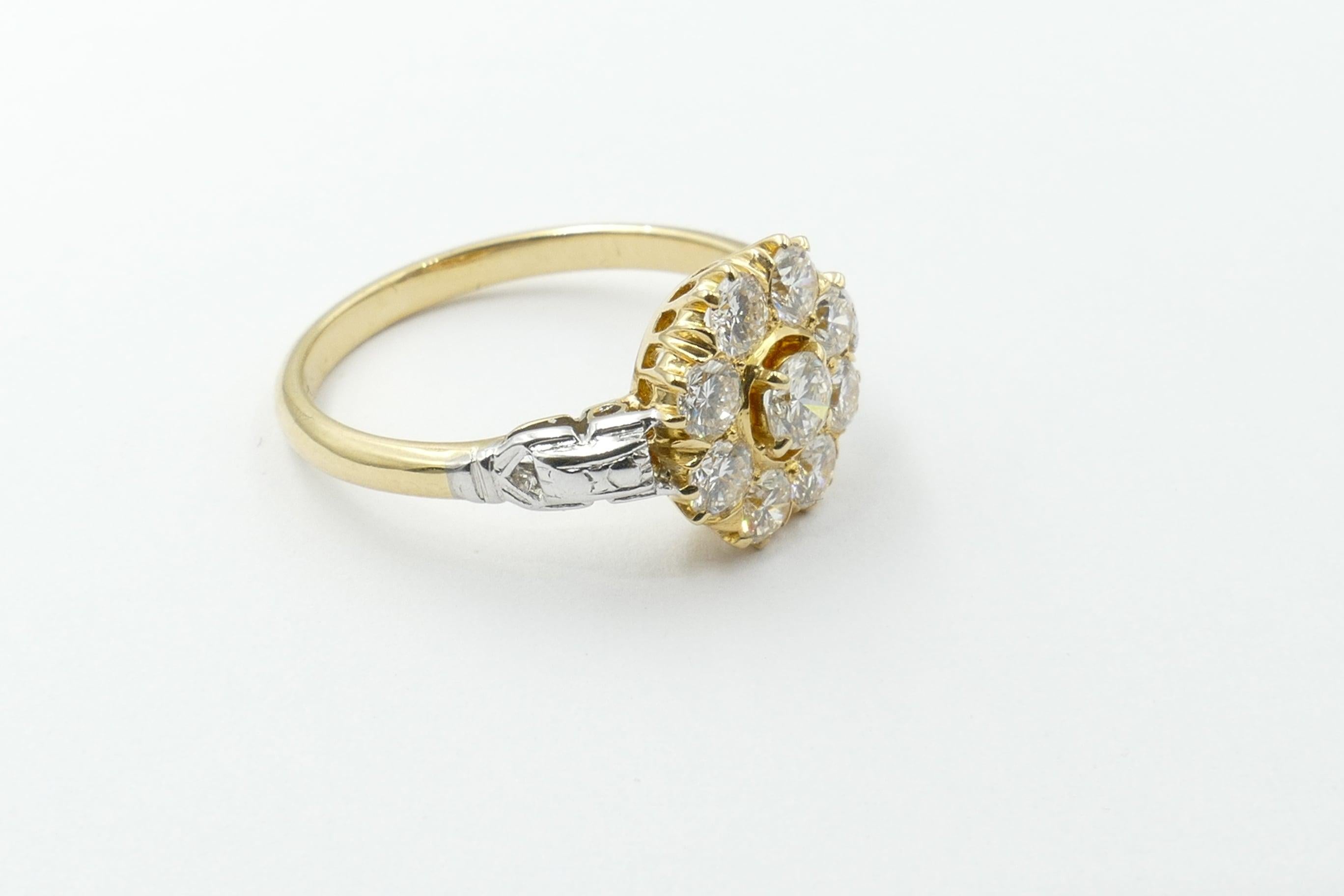 This extremely appealing Diamond Flower Ring features a 0.15 carat Round Brilliant Cut Diamond of Very High Quality Colour being F/G, Clarity VS2, 4 claw set. It is edged to stand out by a ring around the stone of yellow gold. 
As well there are 8