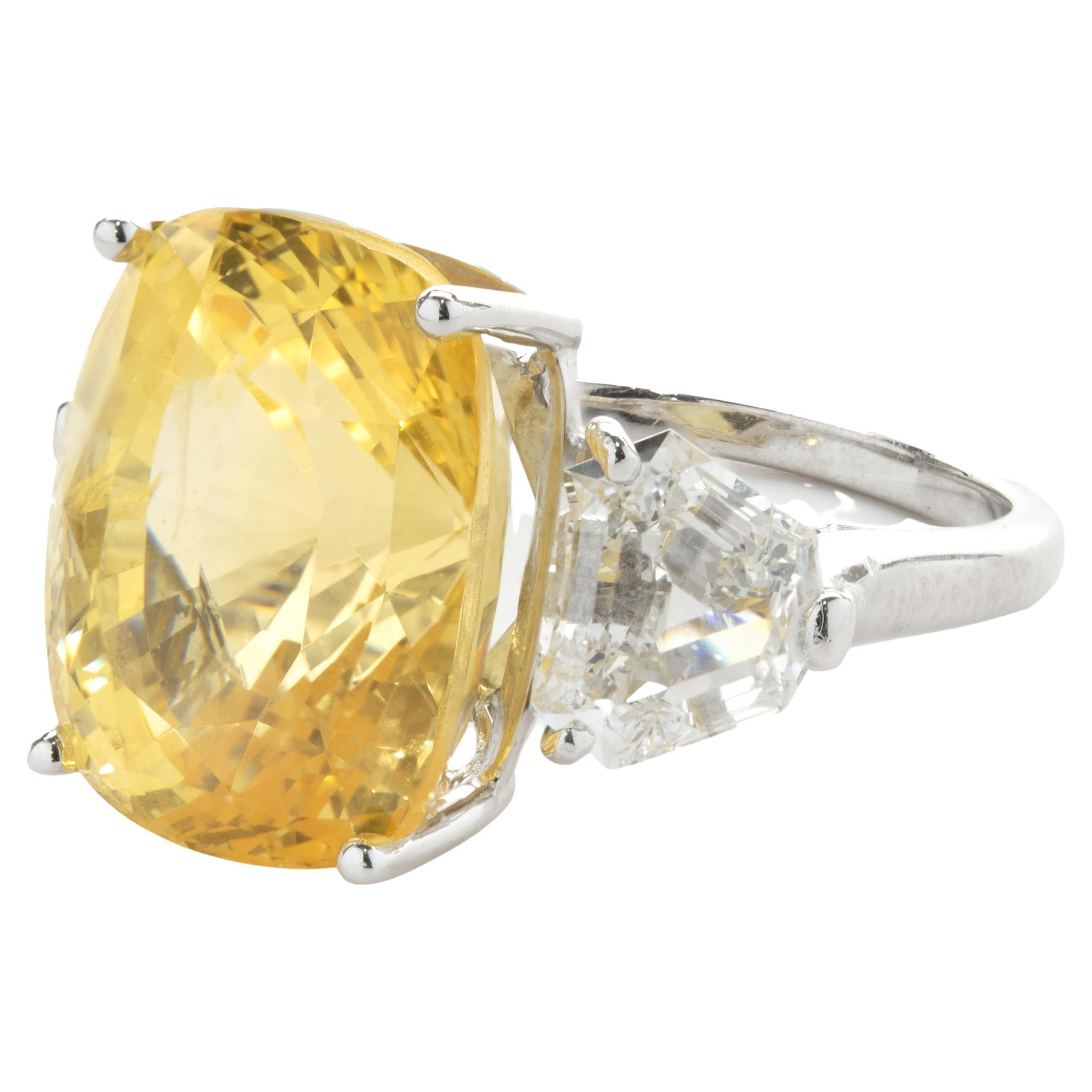 Designer: custom
Material: Platinum
Diamond: 2 trapezoid cut = 1.70cttw
Color: F
Clarity: VS1-2
Yellow Sapphire: 1 oval cut = 13.14ct
Dimensions: ring top measures 14.63mm wide
Ring Size: 6.5 (complimentary sizing available)
Weight: 9.13 grams
