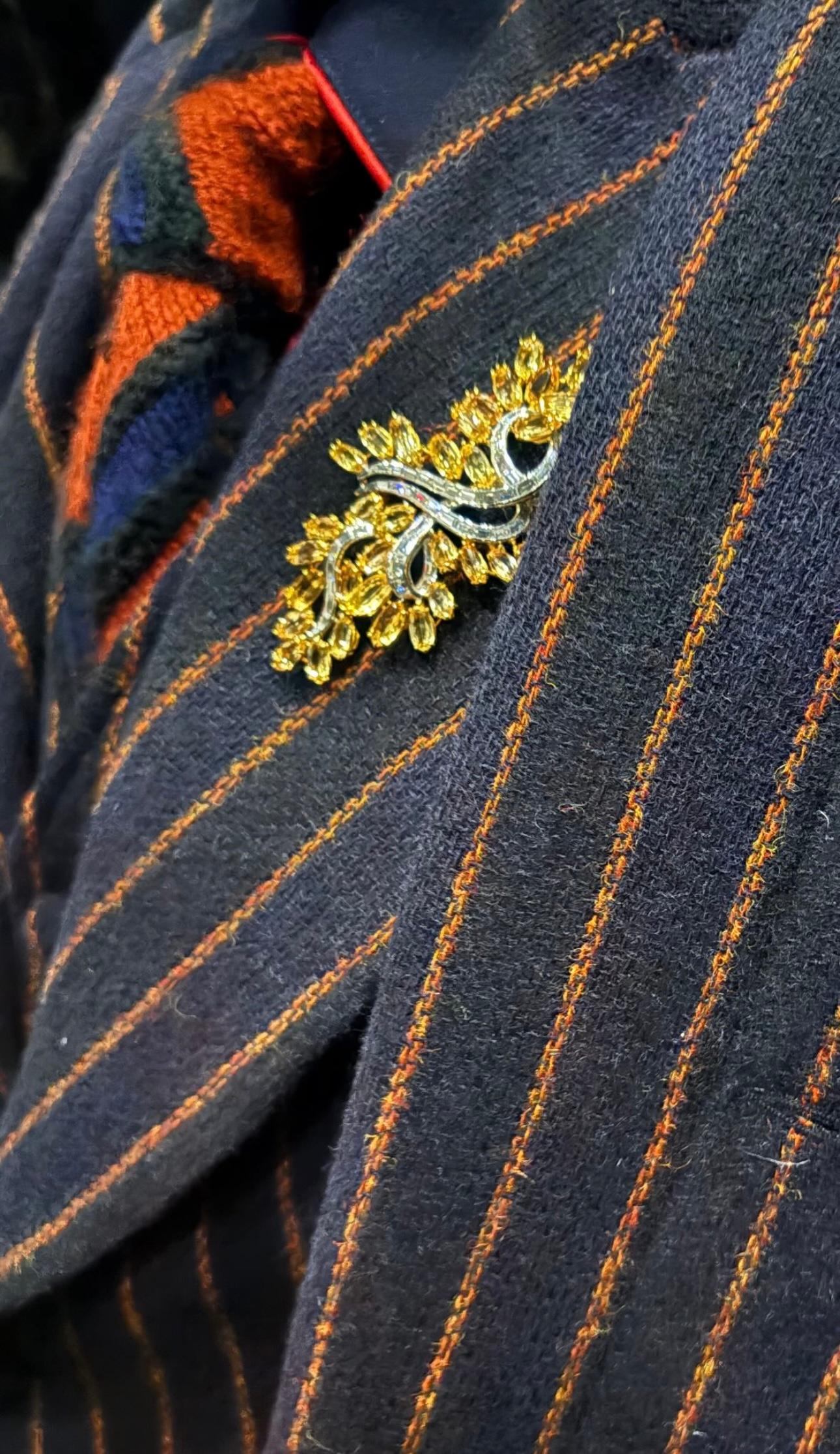 Éblouissante pièce d'apparat des années 1970, cette broche en platine en forme de spray floral met en valeur 34 topazes jaunes taillées en marquise, totalisant environ 24,68 carats. S'épanouissant comme un feuillage doré, la topaze vibrante est mise