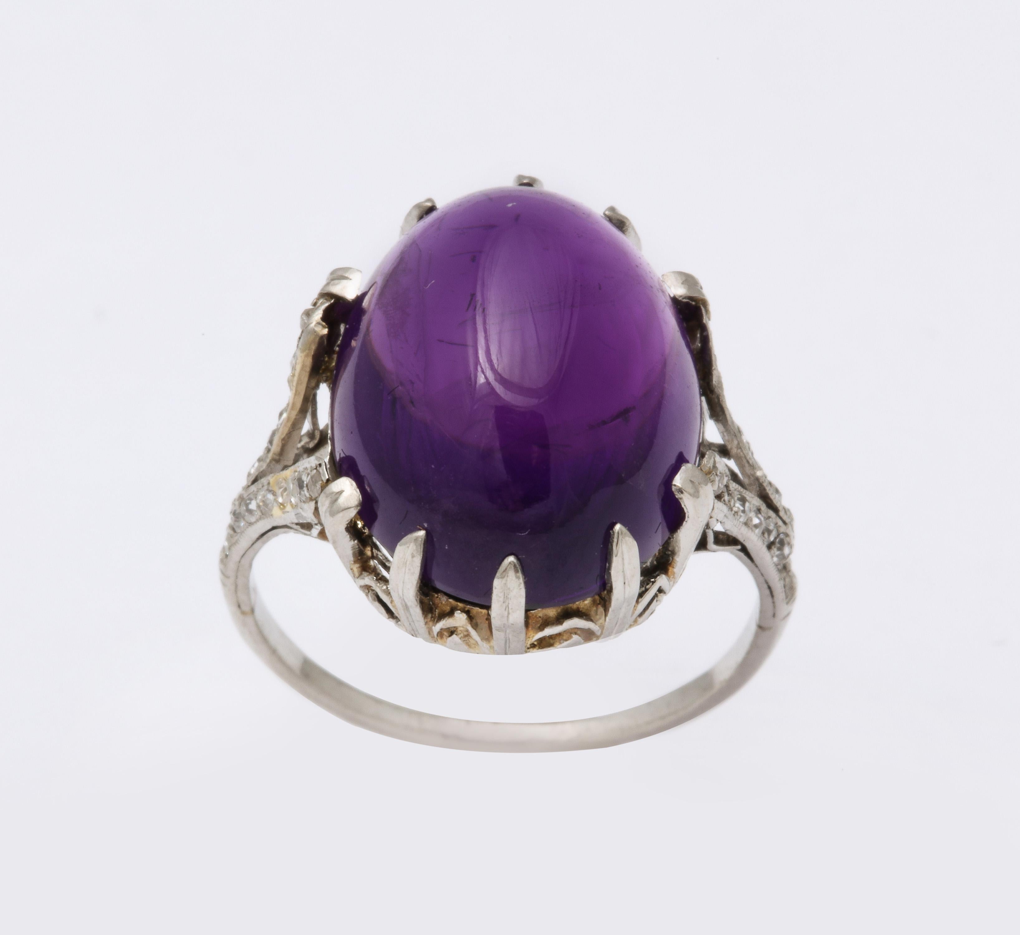 Beautiful Prong set Oval cabochon Amethyst Ring set on lacy mounting with old mine Diamonds on the split shank.  Ca 1915-25.  Very old world and sophisticated.  Approximately 9.5 carats.