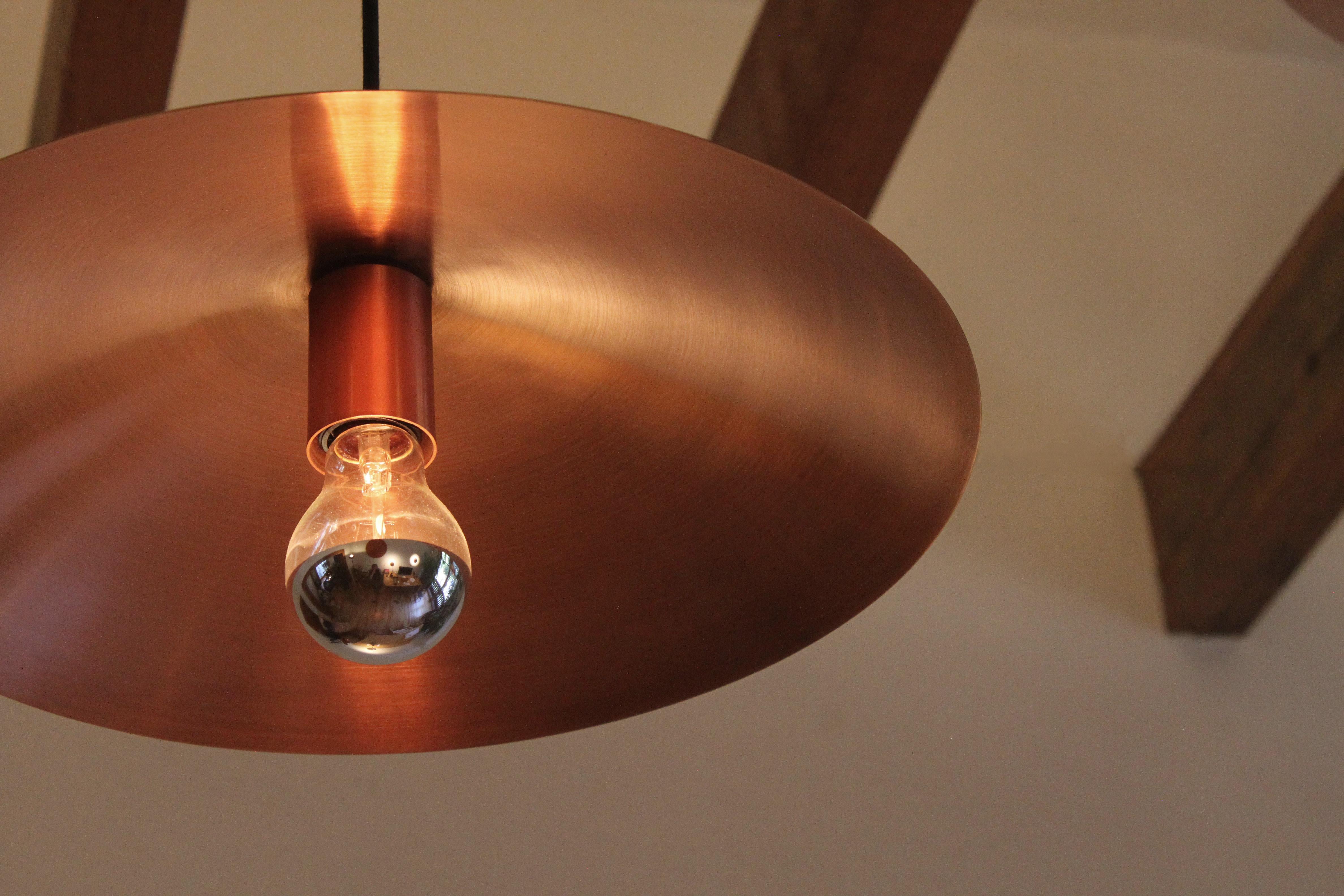 This Plato Abajo ceiling lamp is made of solid copper and oak wood with polished and antique finish, in size ø60. Matte finish. Full dimensions: ø 60 x 20 cm.

Plato Abajo pendant lamp is available in multiple dimensions and